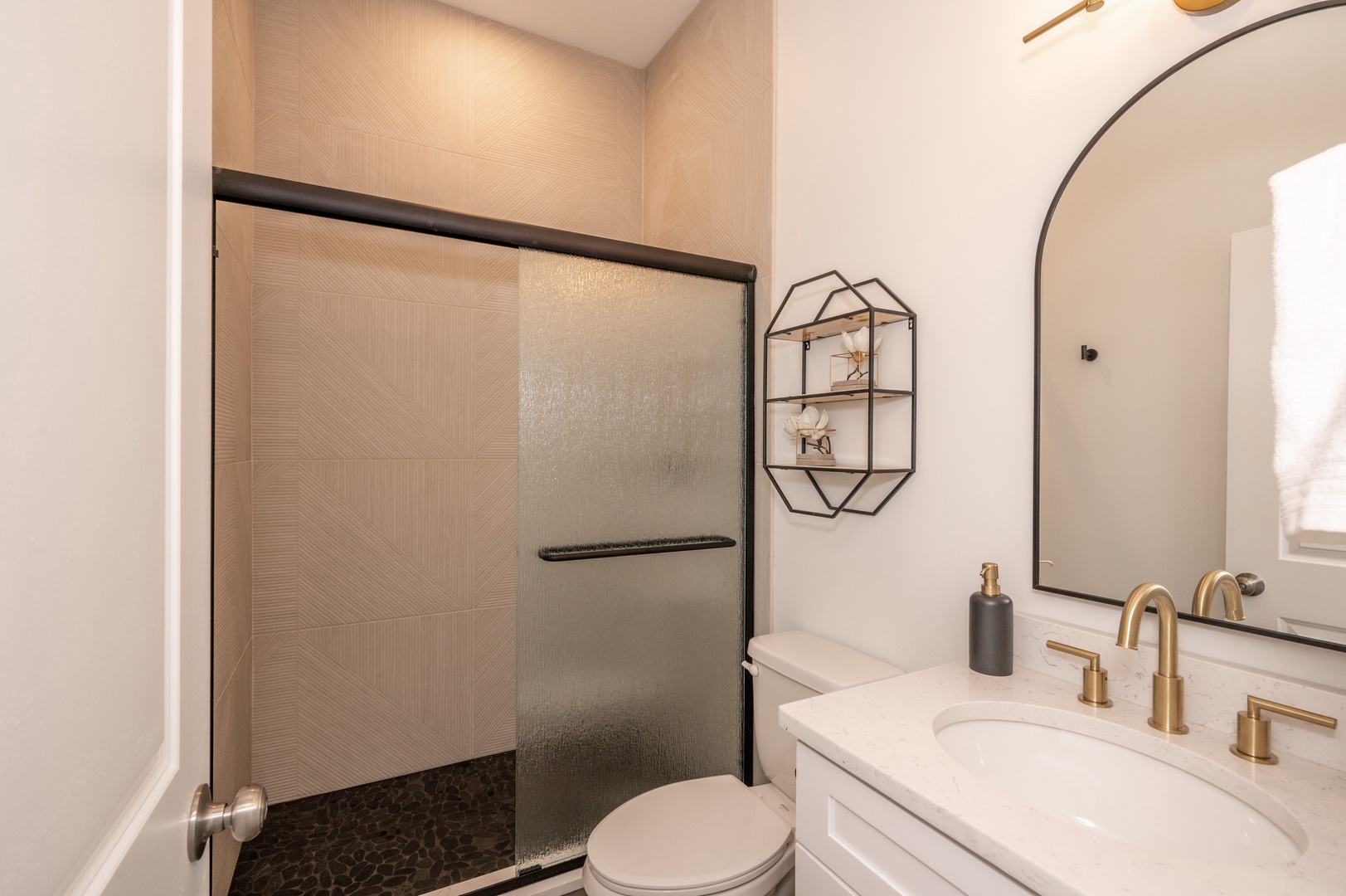 The bathroom offers a chic single vanity and spa-like glass shower