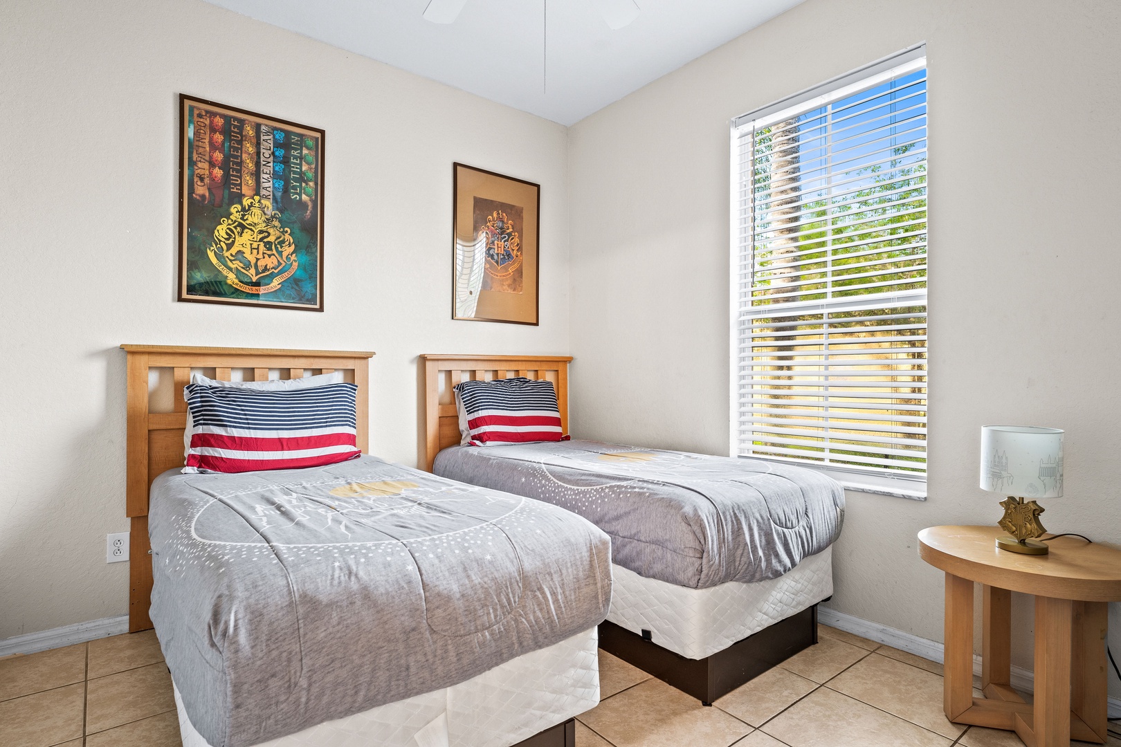 Double twin bedroom with ceiling fan and Harry Potter-themed wall art