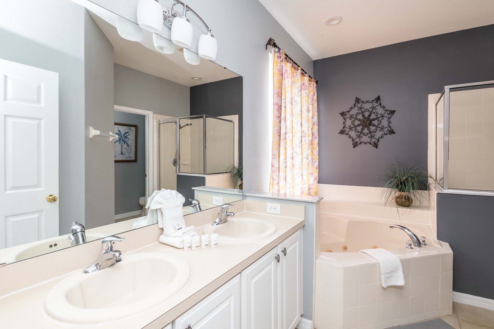 This ensuite bath features a double vanity, glass shower, and soaking tub