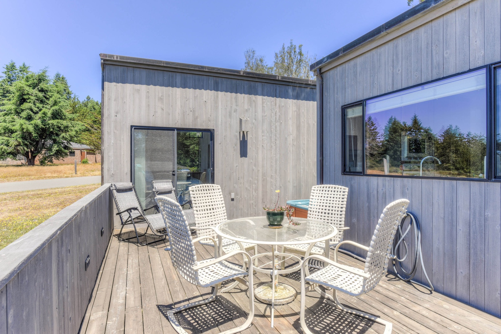 Deck with BBQ, seating, hot tub, and ocean views