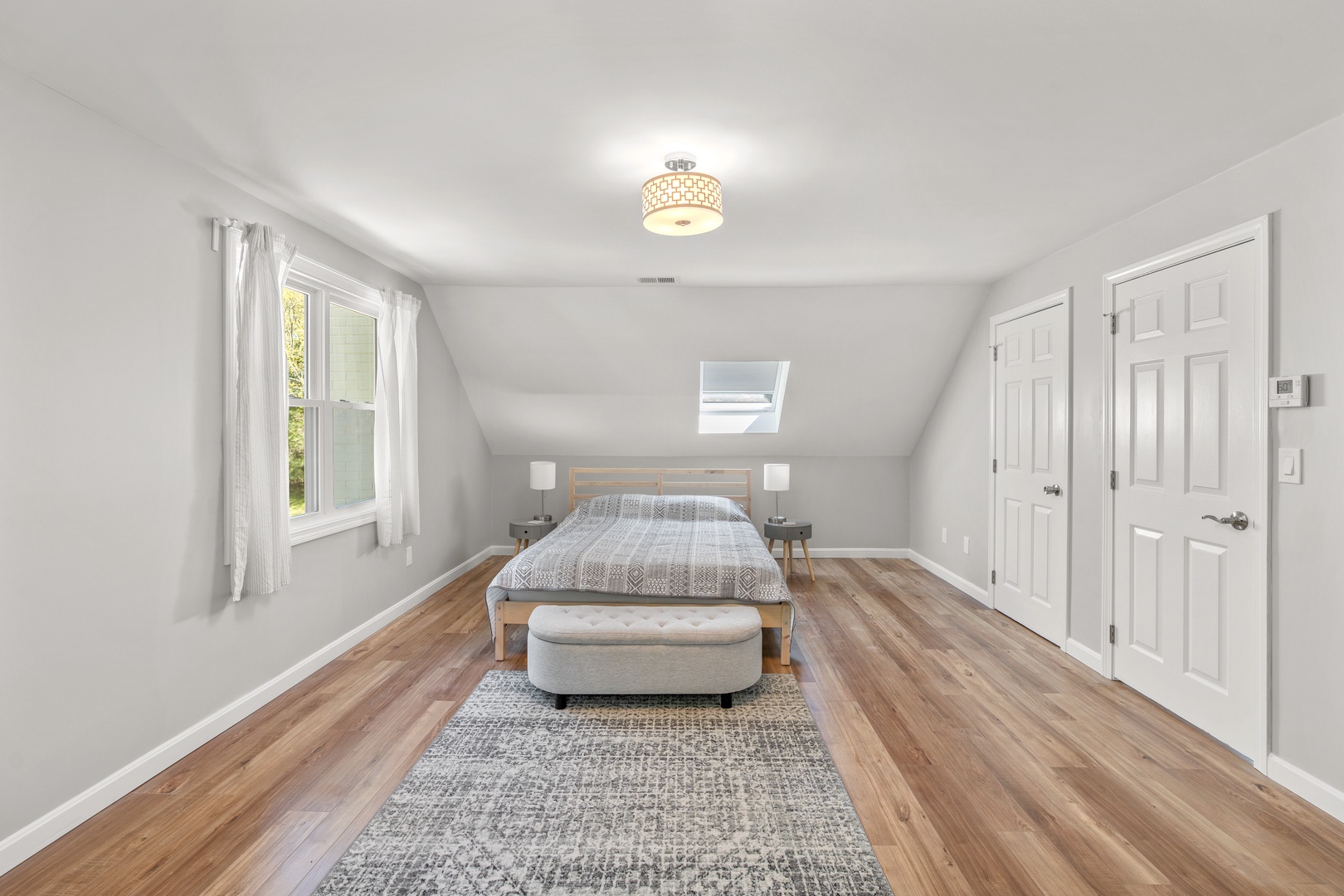 This light-filled bedroom on the 2nd floor offers a sleek queen-sized bed