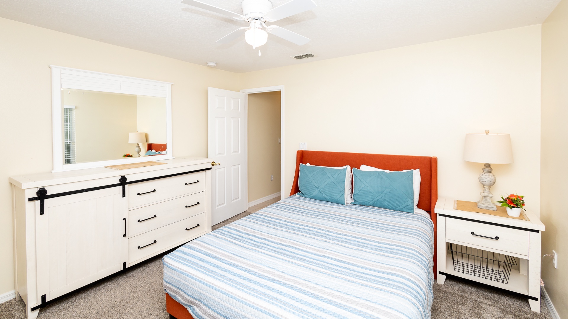 This cozy queen bedroom includes a smart TV and ceiling fan