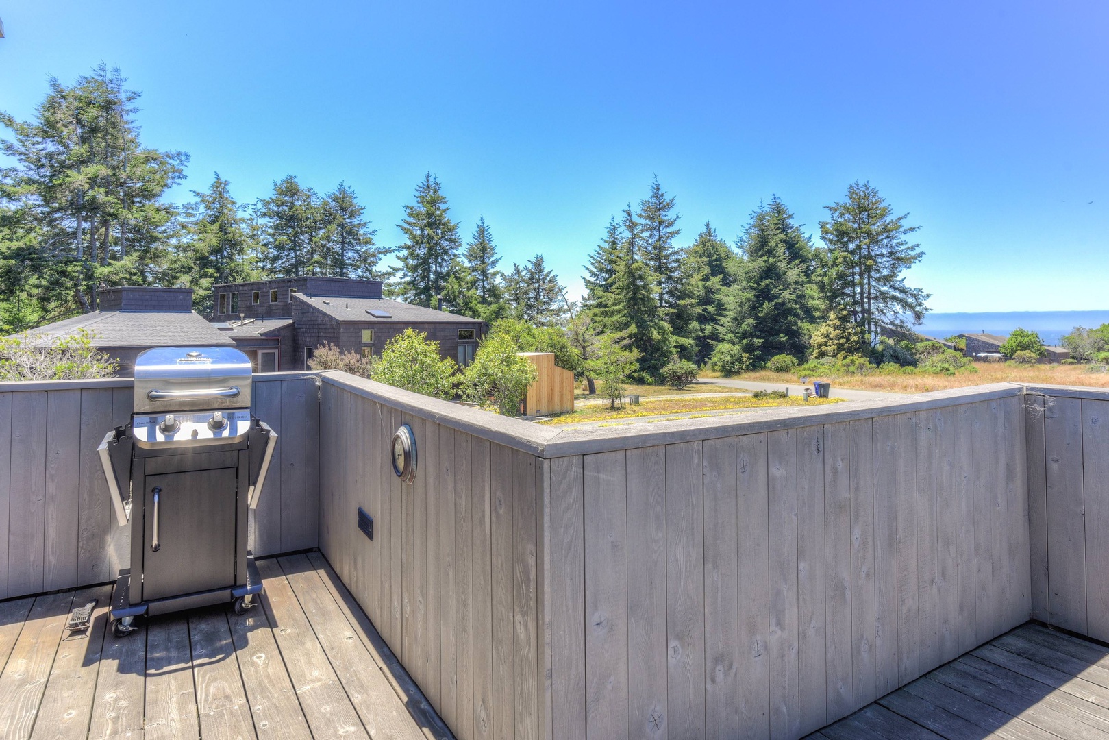 Deck with BBQ, seating, hot tub, and ocean views
