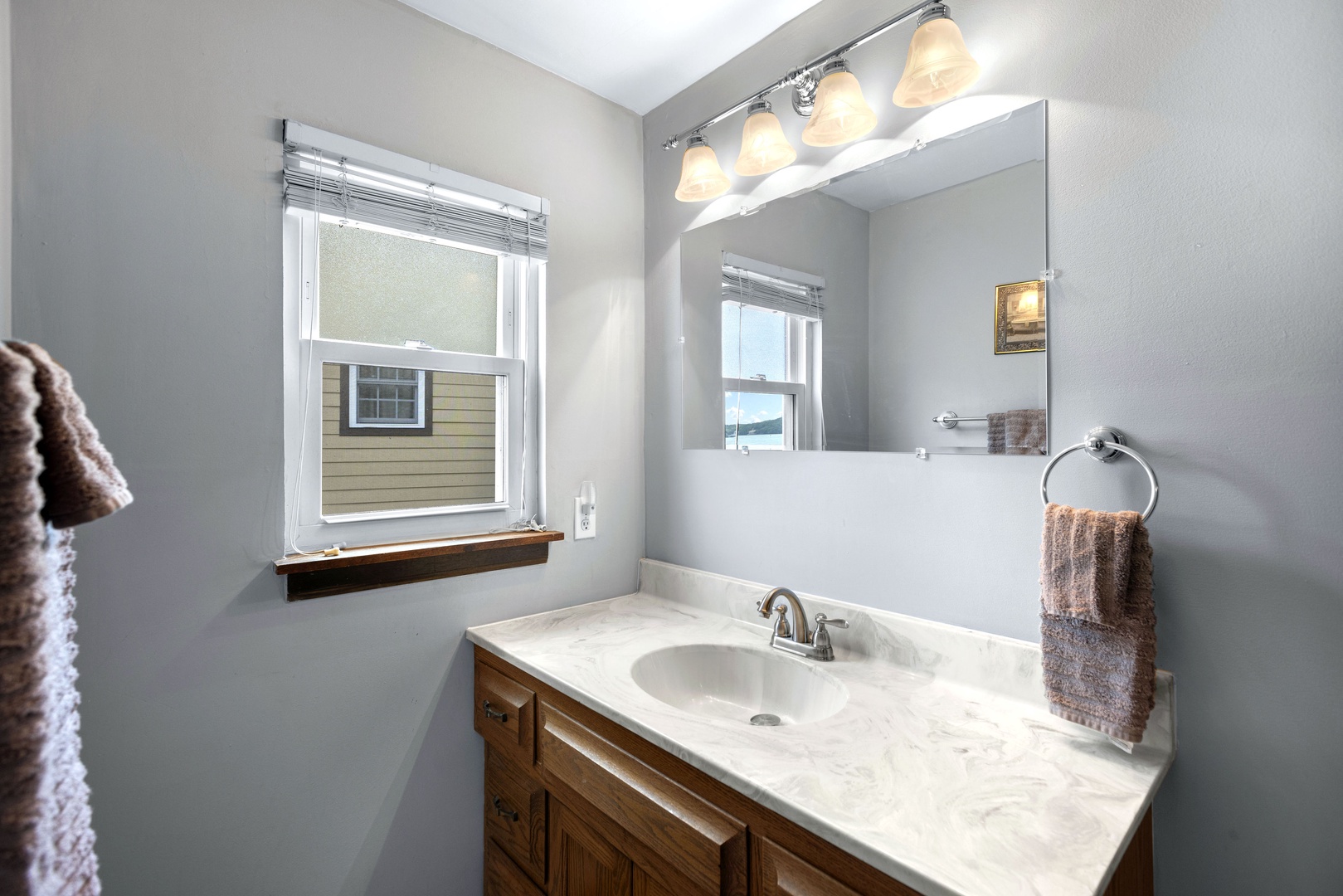 This full bath on the lower level includes a large vanity & shower/tub combo