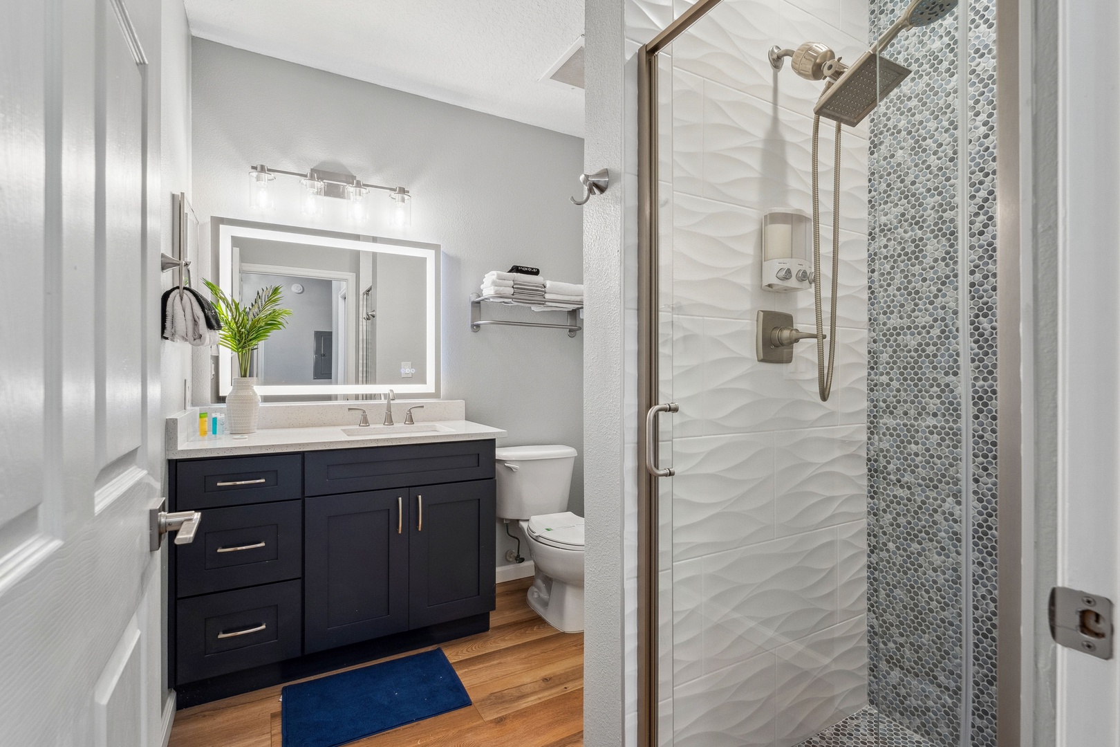 The shared full bath includes a single vanity & sleek glass shower