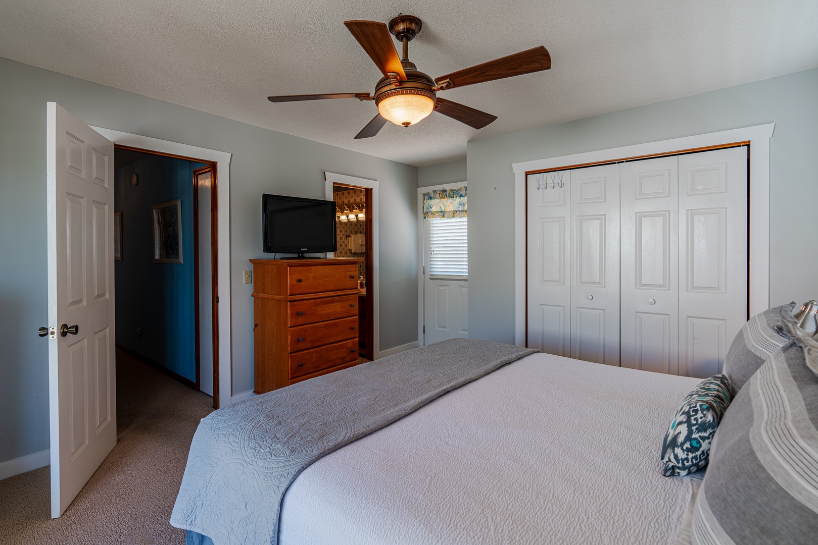 The king suite boasts a private ensuite, ceiling fan, TV, & balcony access