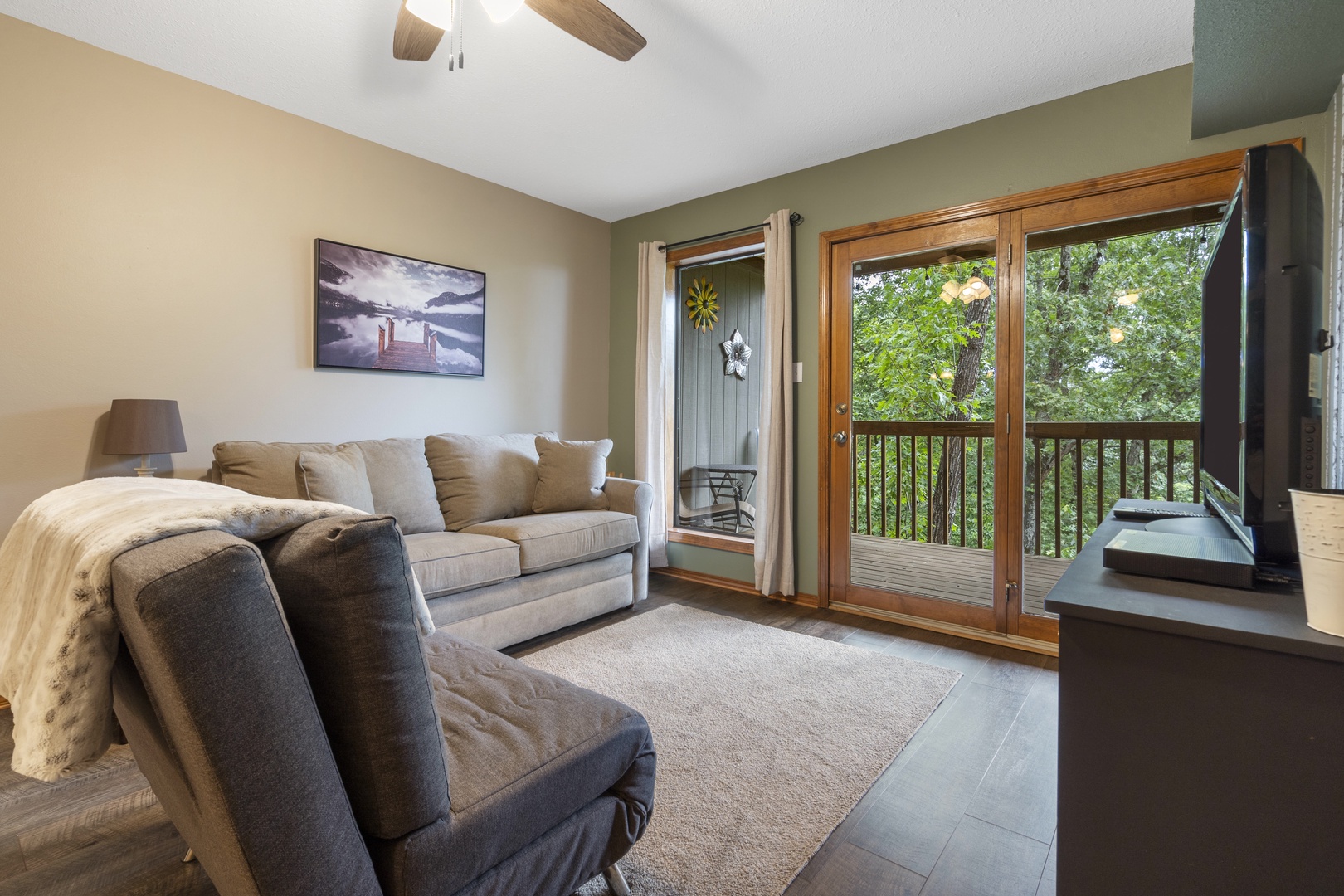 Cozy living area with ceiling fan, cable TV & deck access