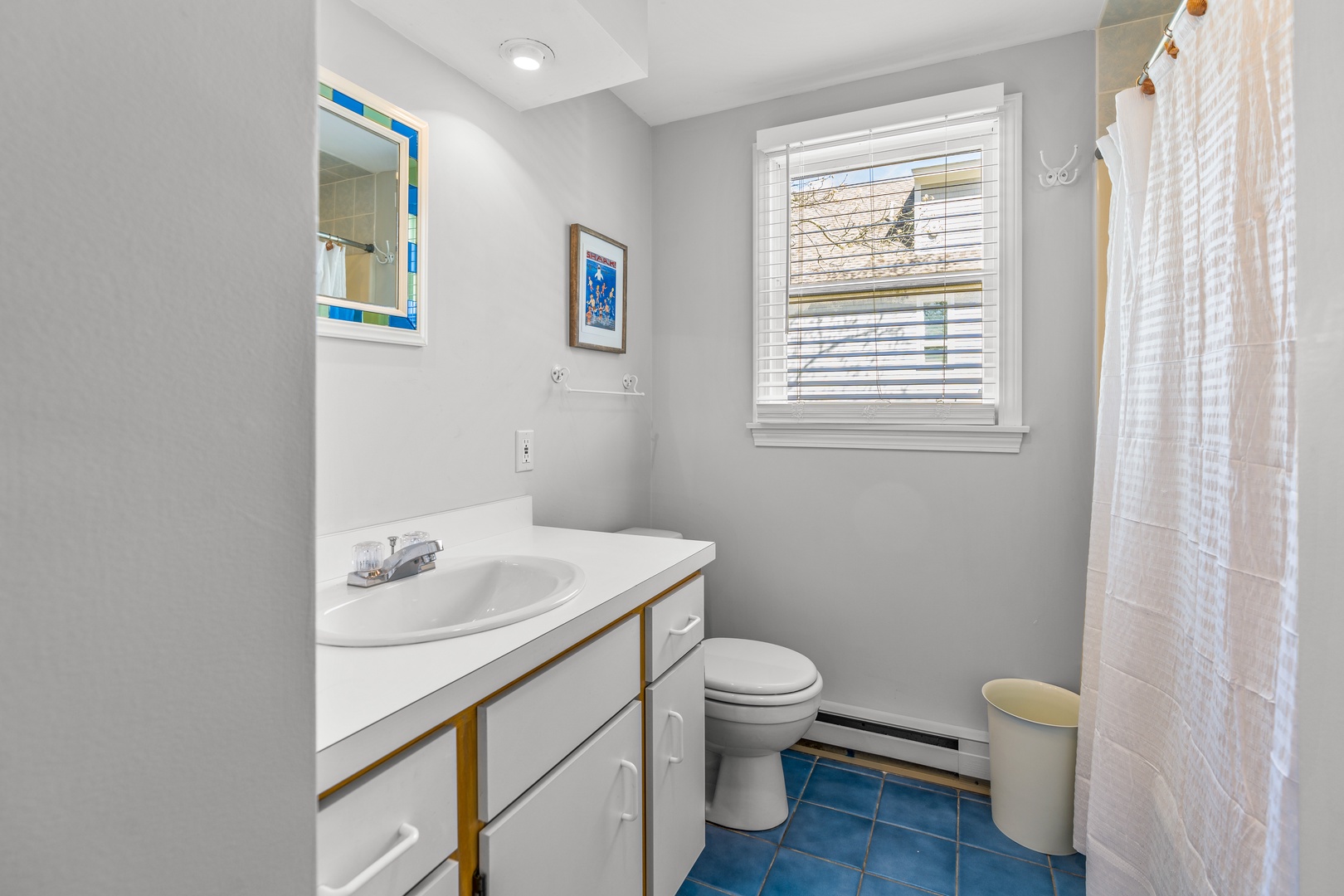 This full bathroom features a single vanity & shower/tub combo