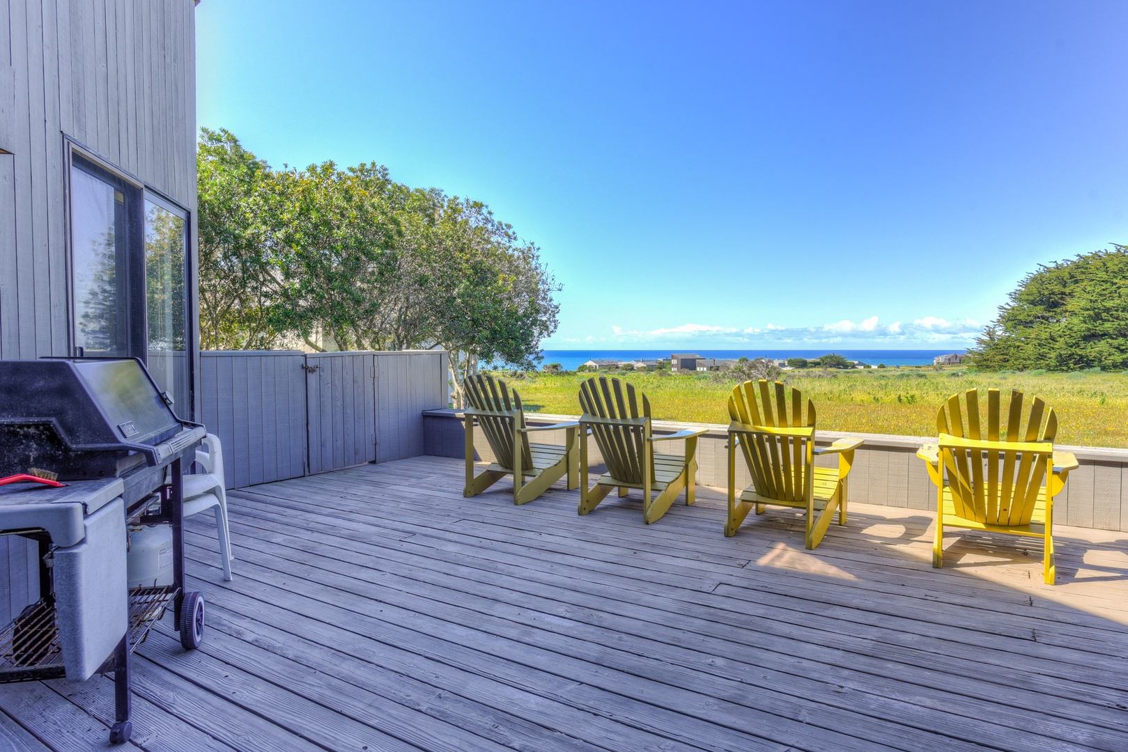 Large back deck with partial ocean view and outdoor seating
