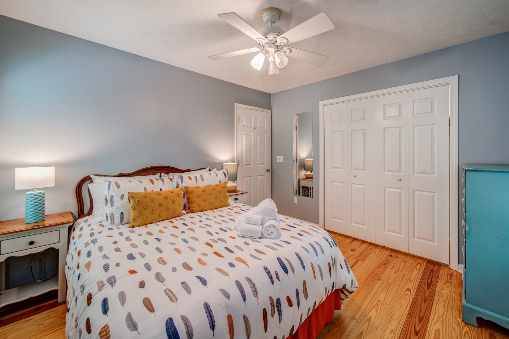 The second of two queen bedrooms, with a dresser & ceiling fan