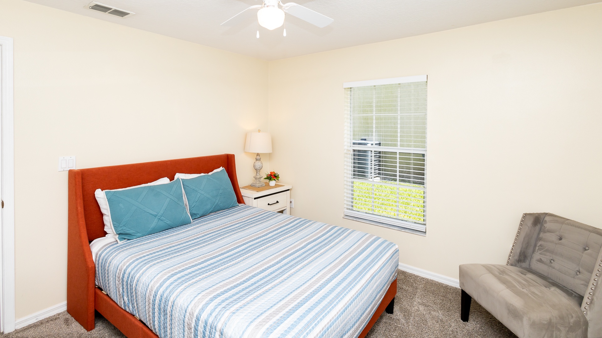 This cozy queen bedroom includes a smart TV and ceiling fan