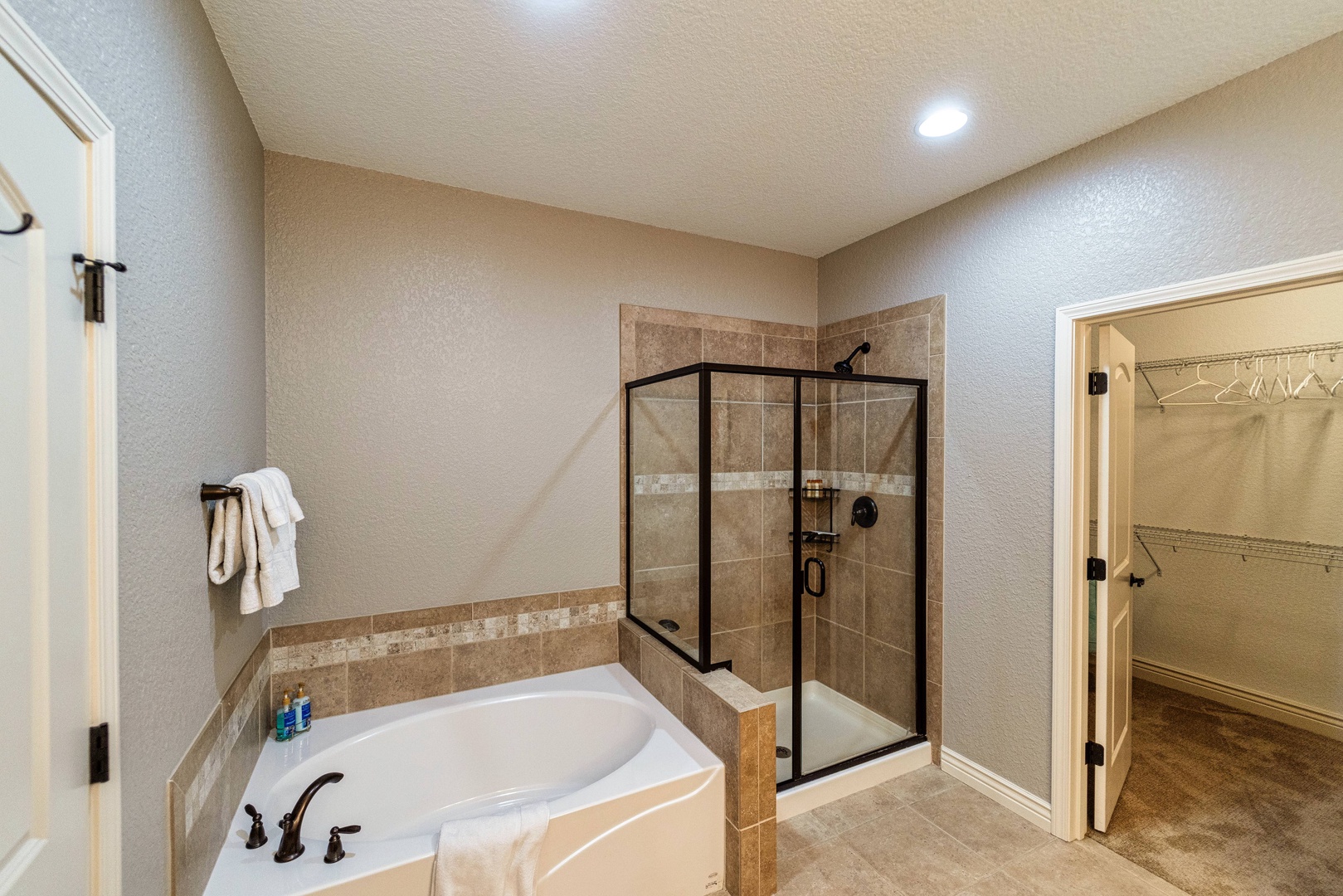 En-suite with dual sinks, soaking tub, and stand-up shower