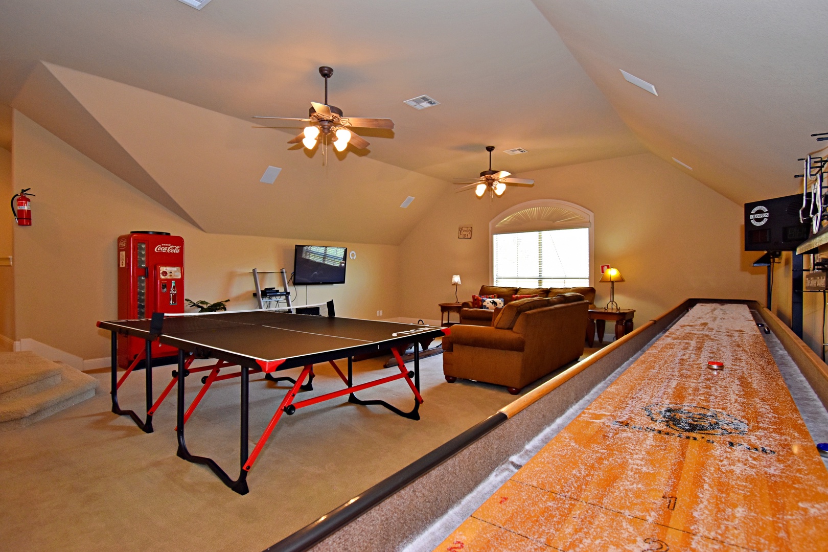 Upstairs game room, offering shuffleboard, ping-pong, two sofas, a smart TV, and a kitchenette with a sink and mini-fridge (2nd floor).