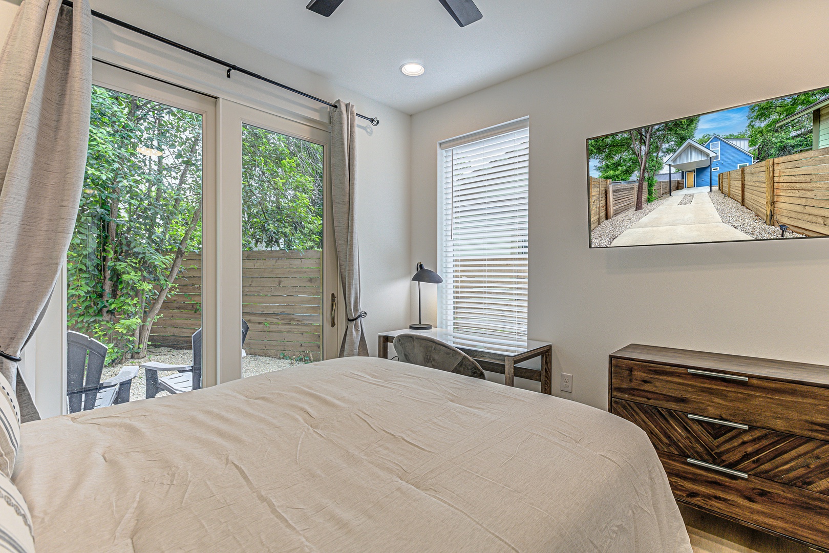 Bedroom 1 with queen bed, patio, workspace, and Smart TV