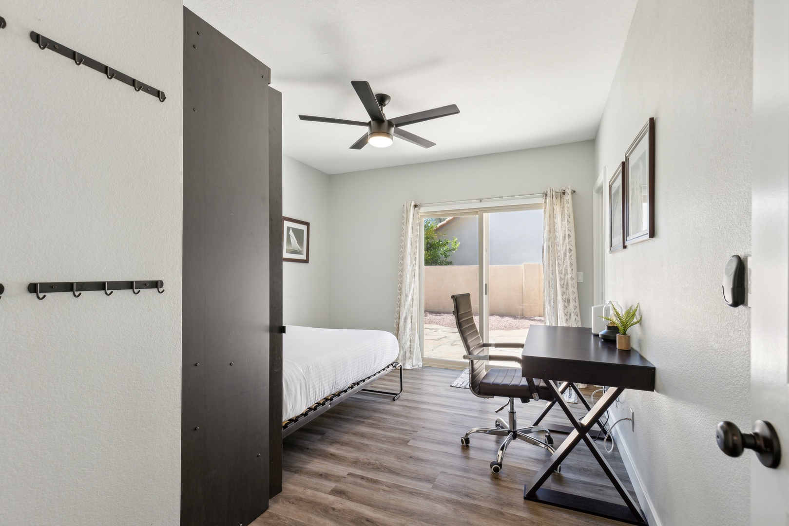 Bedroom 1 with queen murphy bed, workspace, and patio access