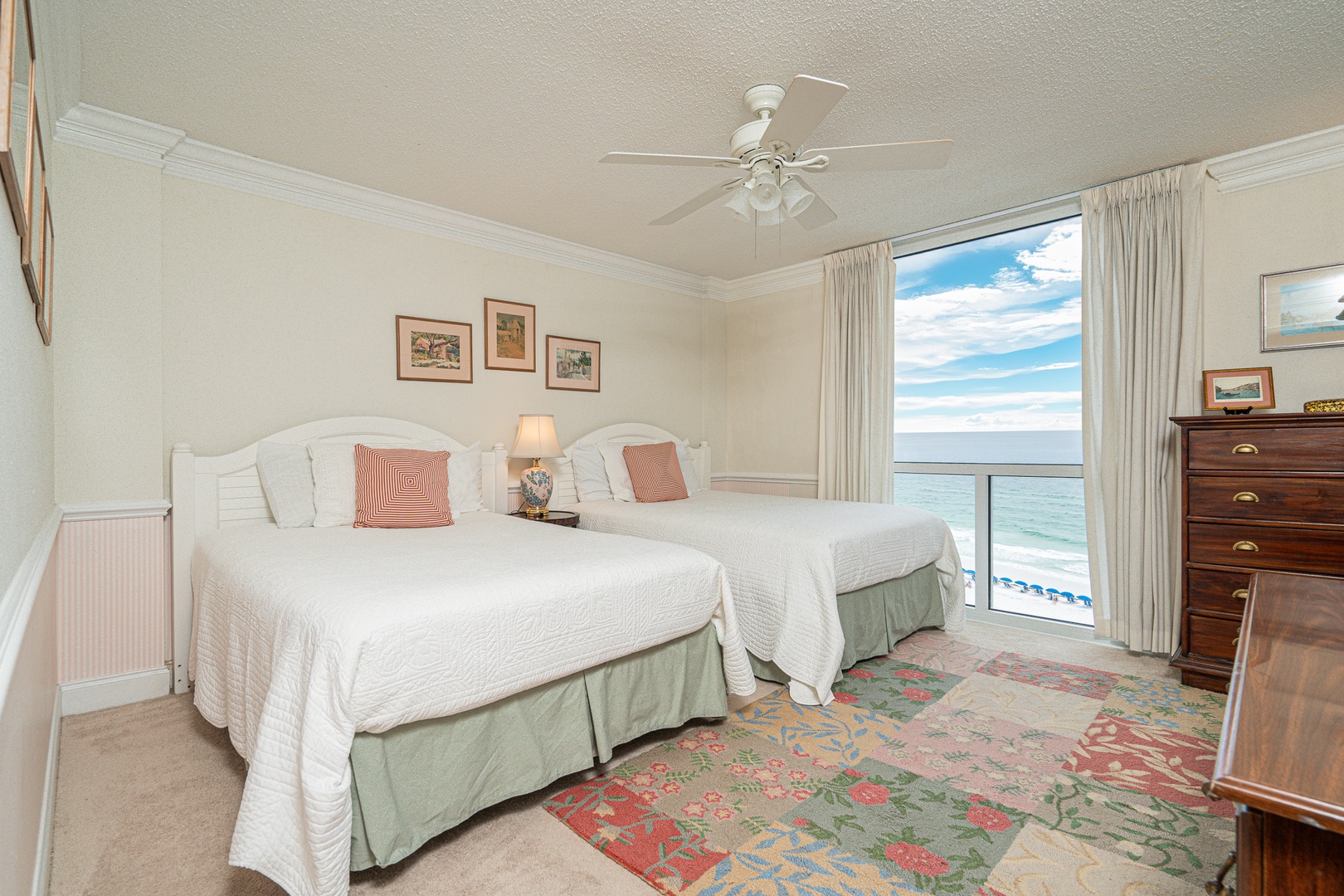 The second bedroom retreat offers two plush full beds, a TV, & beach views