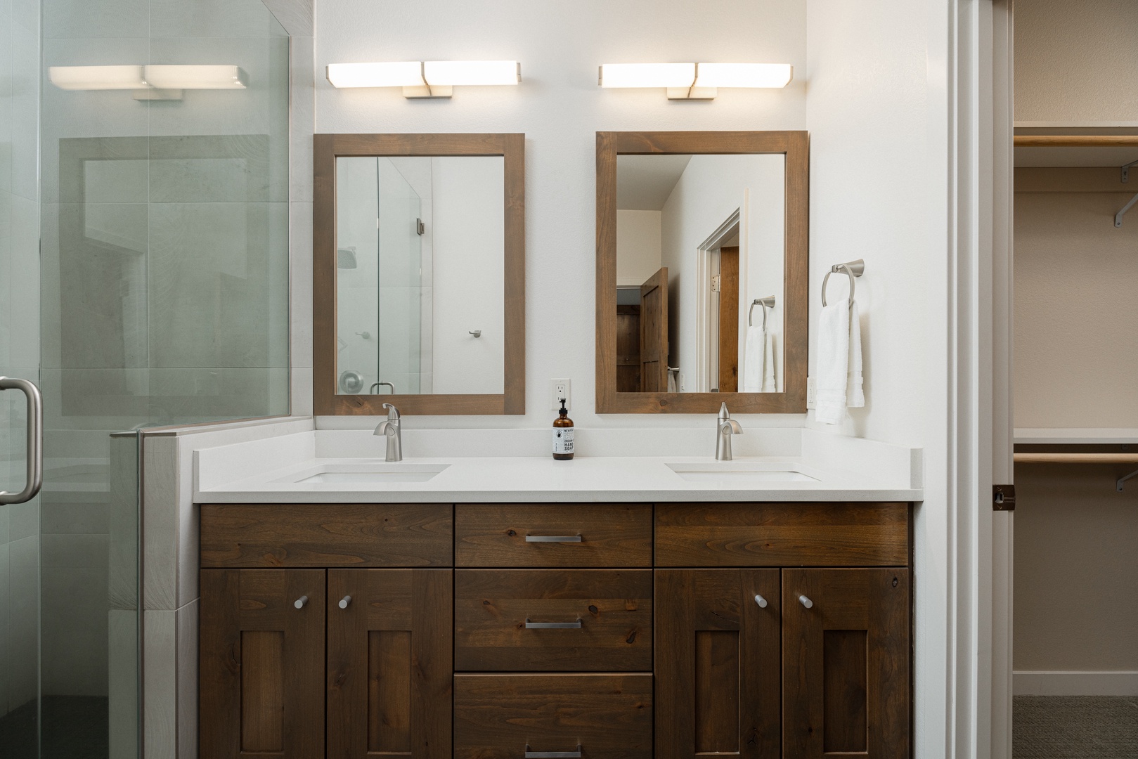 The 2nd-floor ensuite offers a dual vanity, glass shower, & large closet