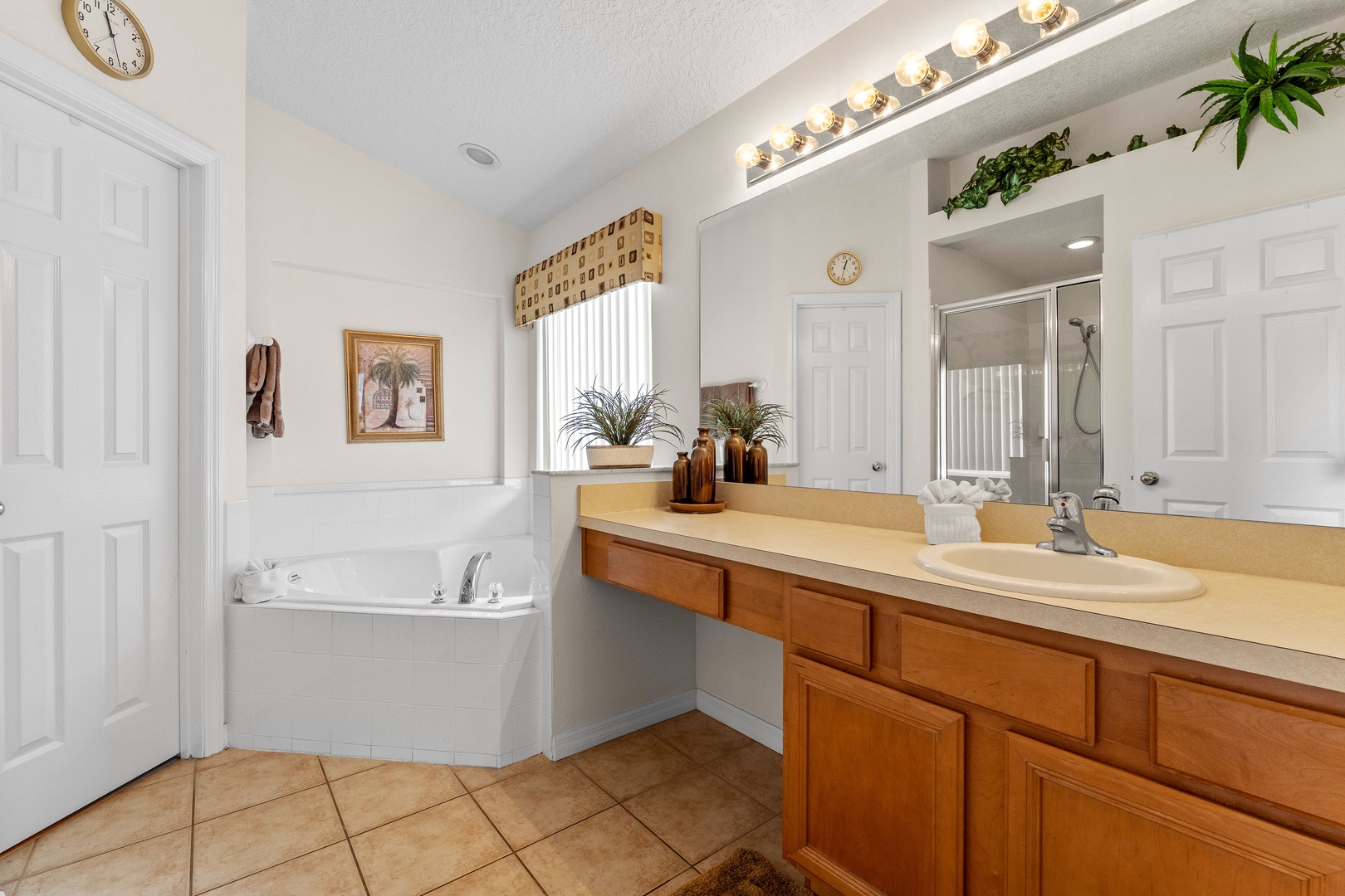 Private ensuite bath with oversized single vanity, soaking tub & separate shower