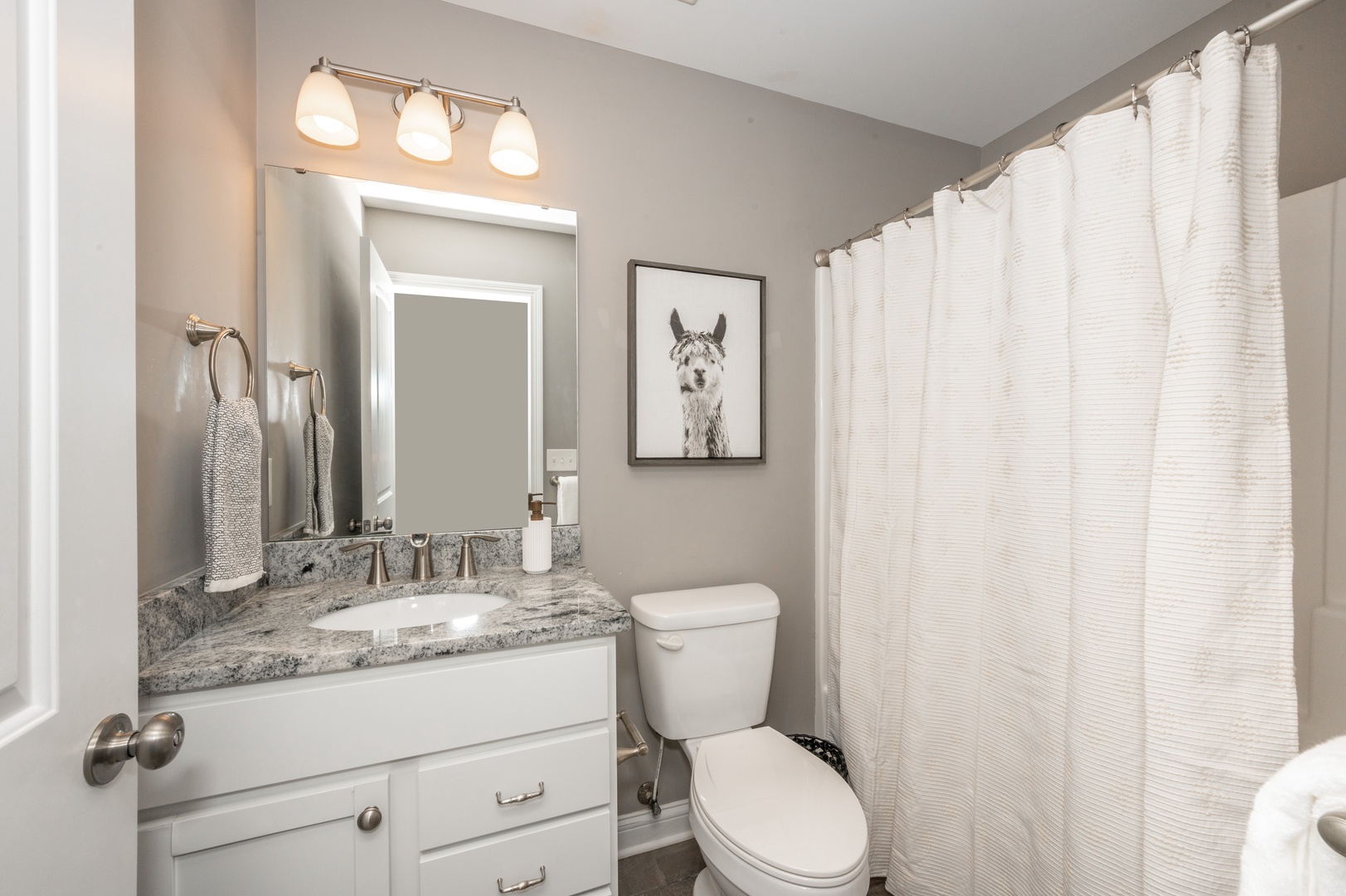 The main level full bathroom includes a single vanity & shower/tub combo