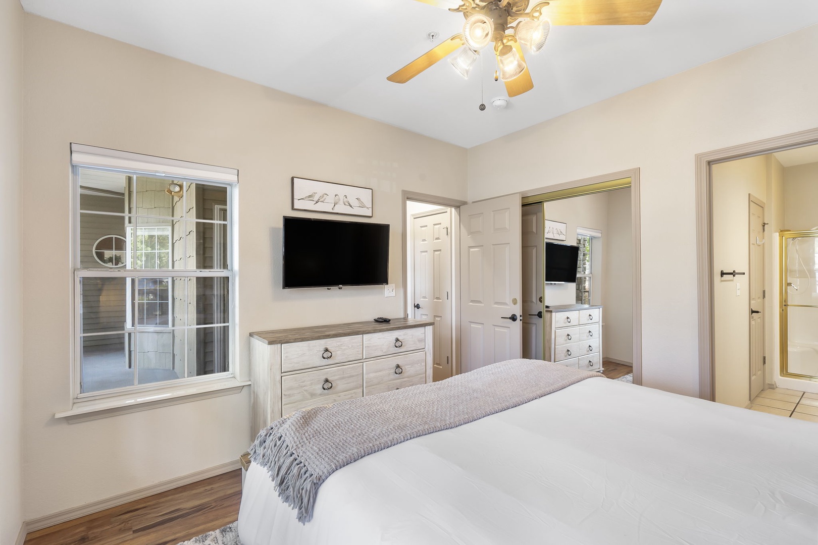 The queen bedroom offers a private en suite, ceiling fan, & TV