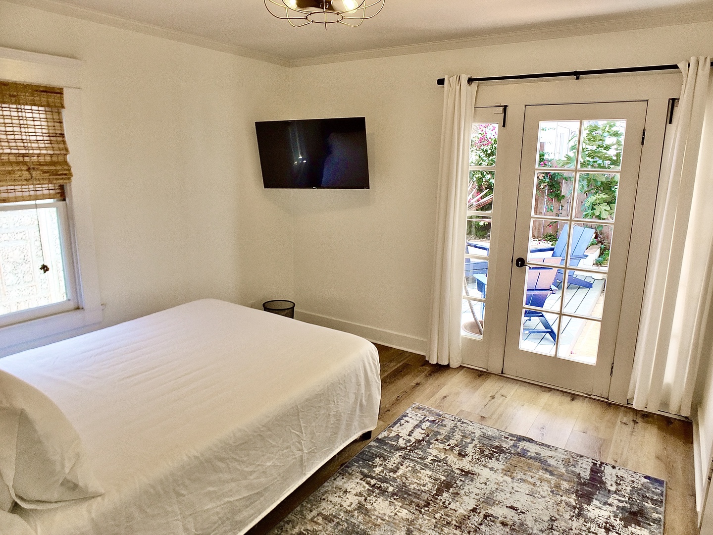 Bedroom 2 with queen bed, Smart TV, and patio access