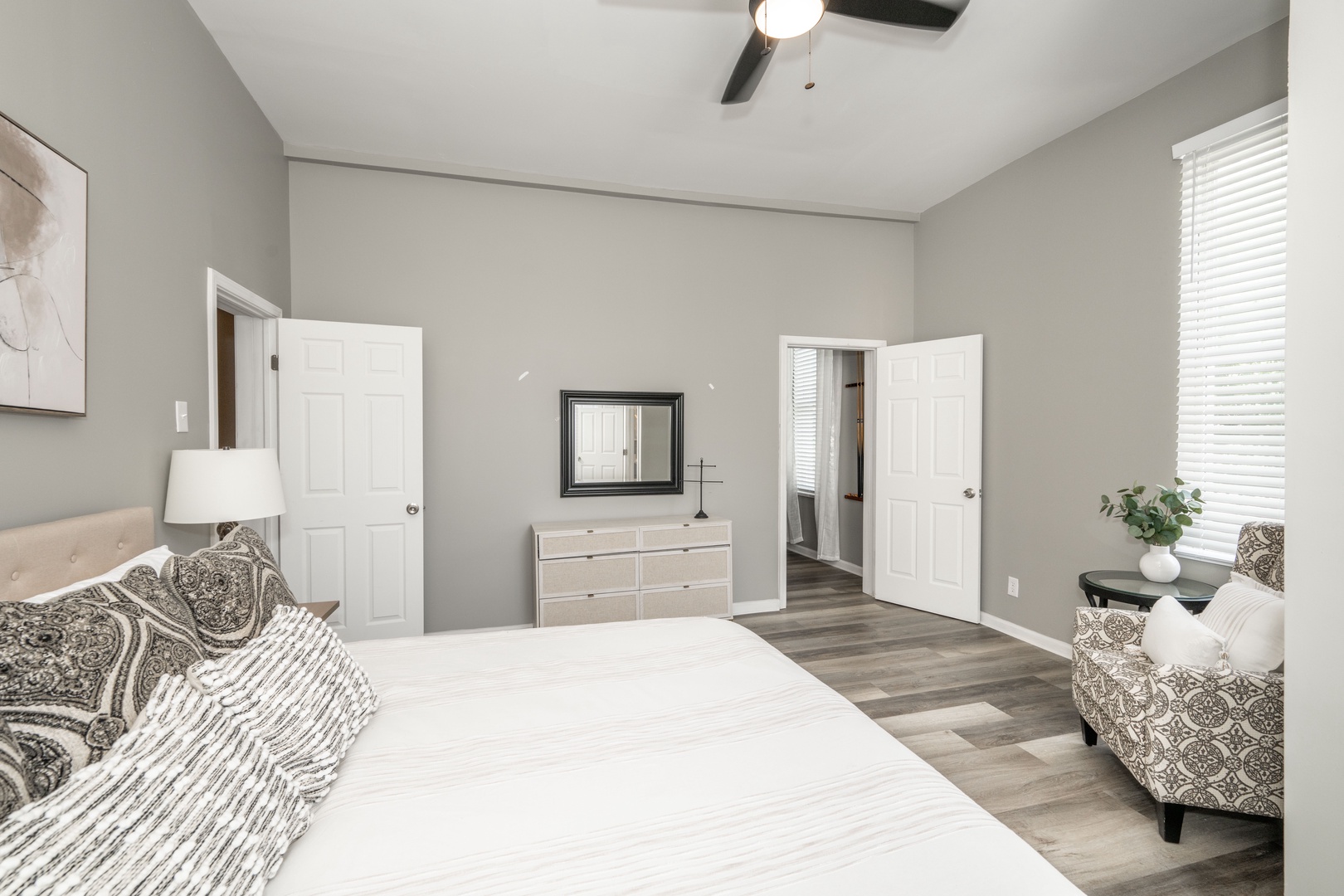 The tranquil 1st floor king bedroom offers a ceiling fan & private half en suite