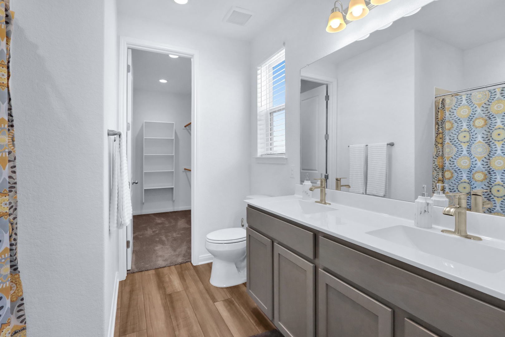 This chic ensuite features dual vanities, shower/tub combo