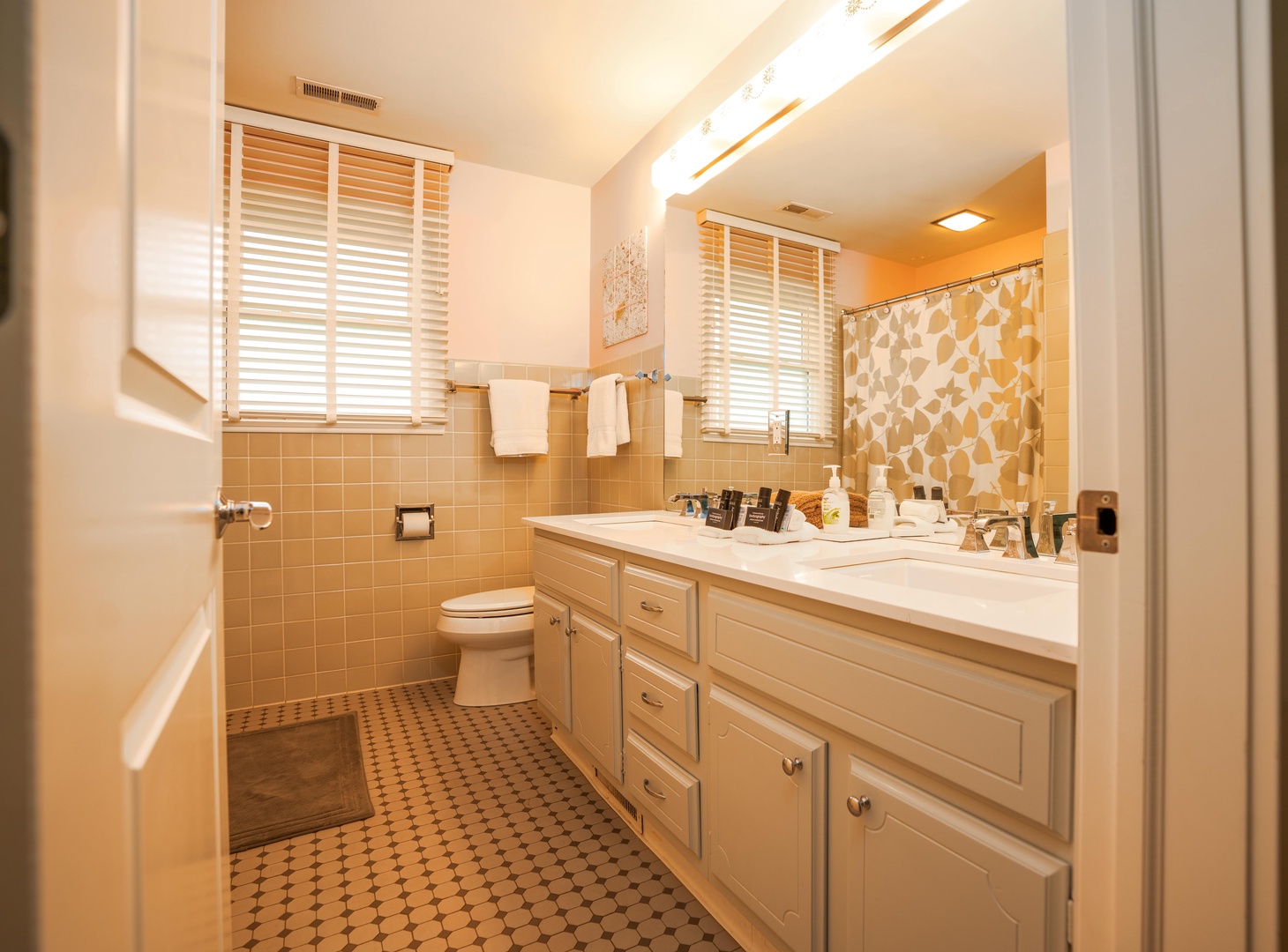 Full bathroom with dual sinks, and shower/tub combo