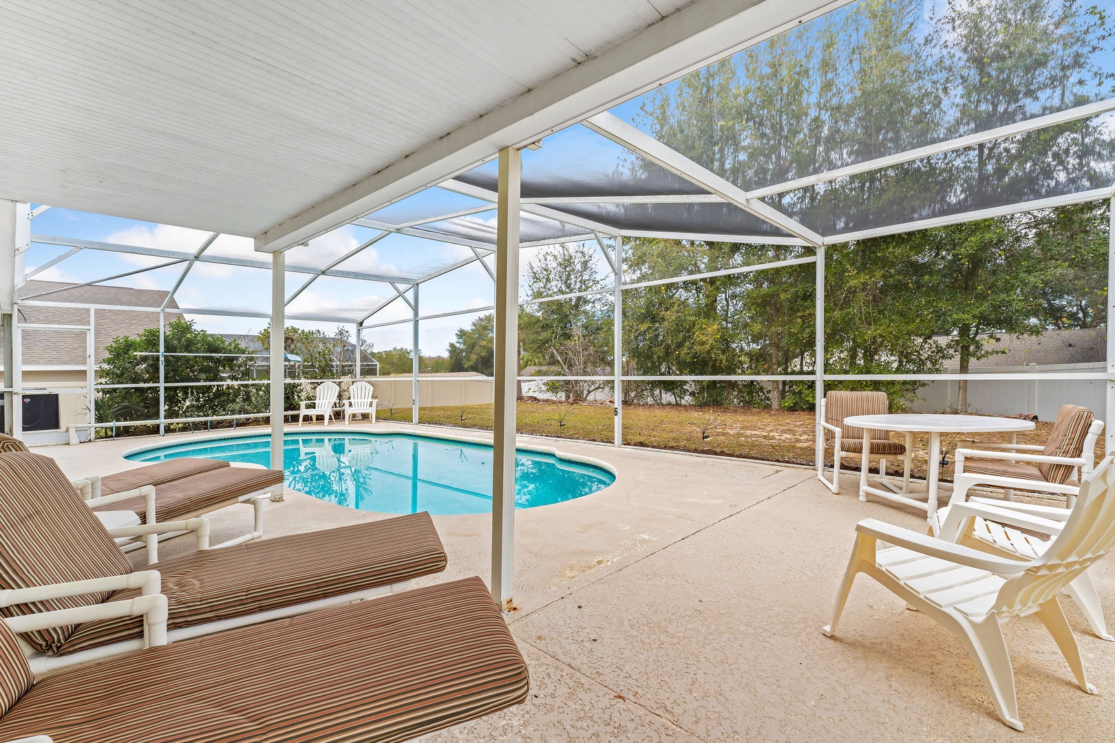 Enjoy the pool and lounge chairs under a serene lanai