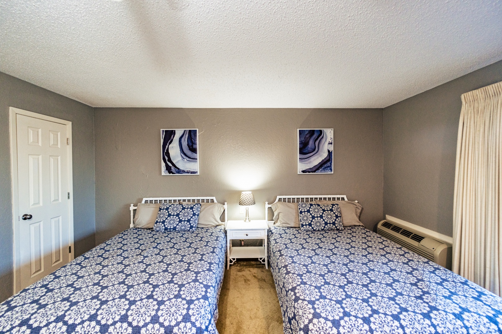 This lower-level suite offers a pair of queen beds, ensuite, Smart TV, & deck access