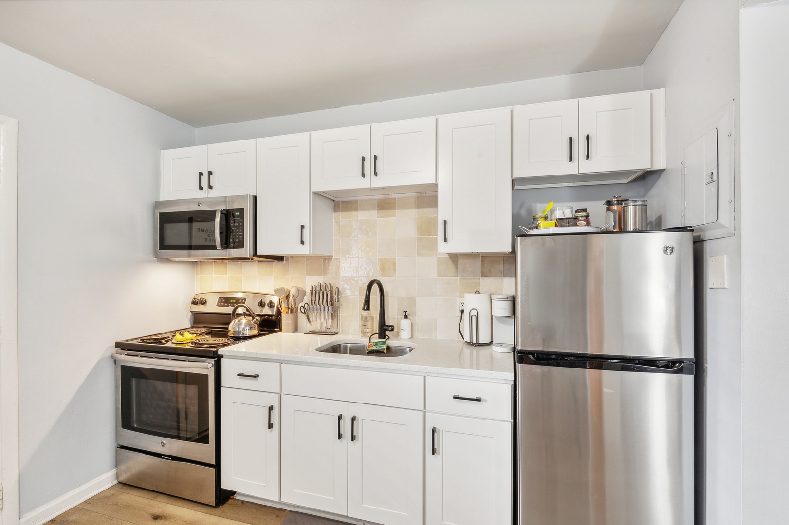 The sleek kitchen offers ample storage space & all the comforts of home