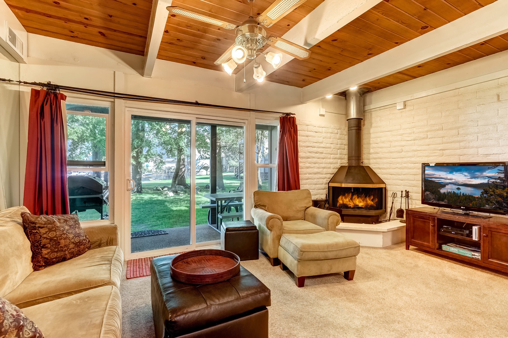 Living room with wood stove, TV, ceiling fan, marina access