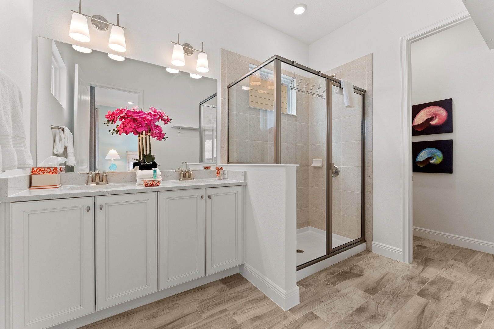 Enjoy a double vanity, glass shower, & private water closet area in this ensuite