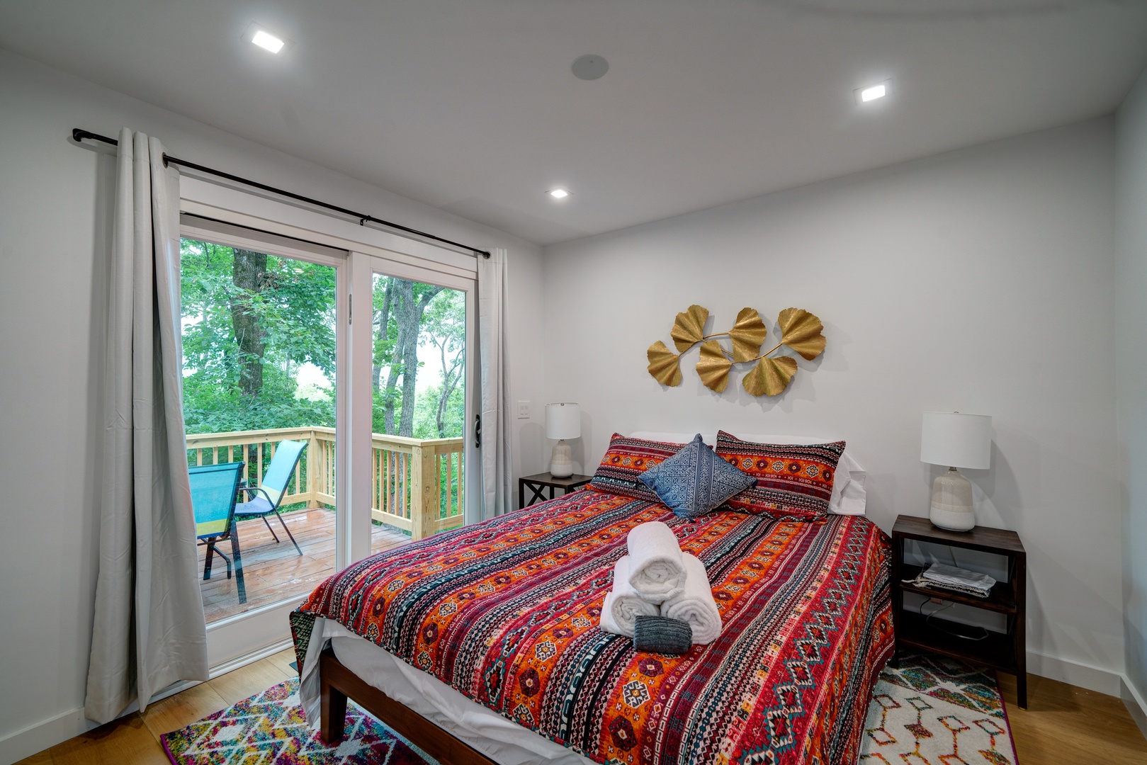 This main-level bedroom retreat boasts a plush queen bed & deck access