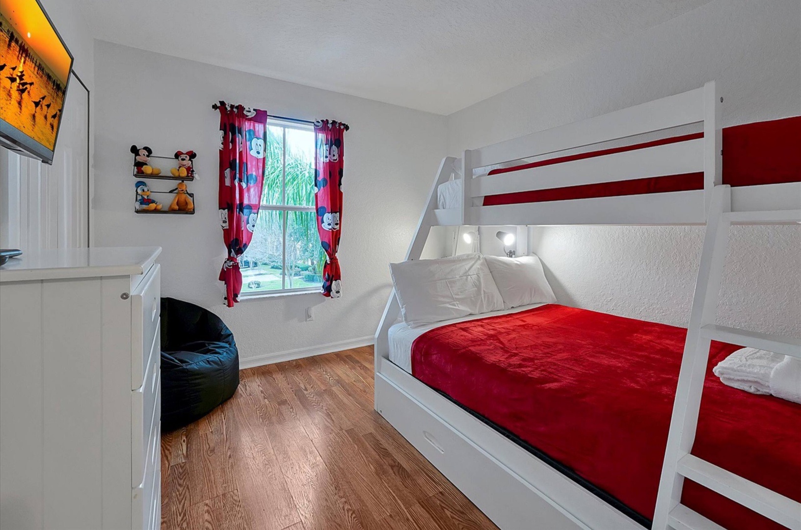 A twin-over-full bunkbed, twin trundle, & TV await in this 2nd-floor bedroom