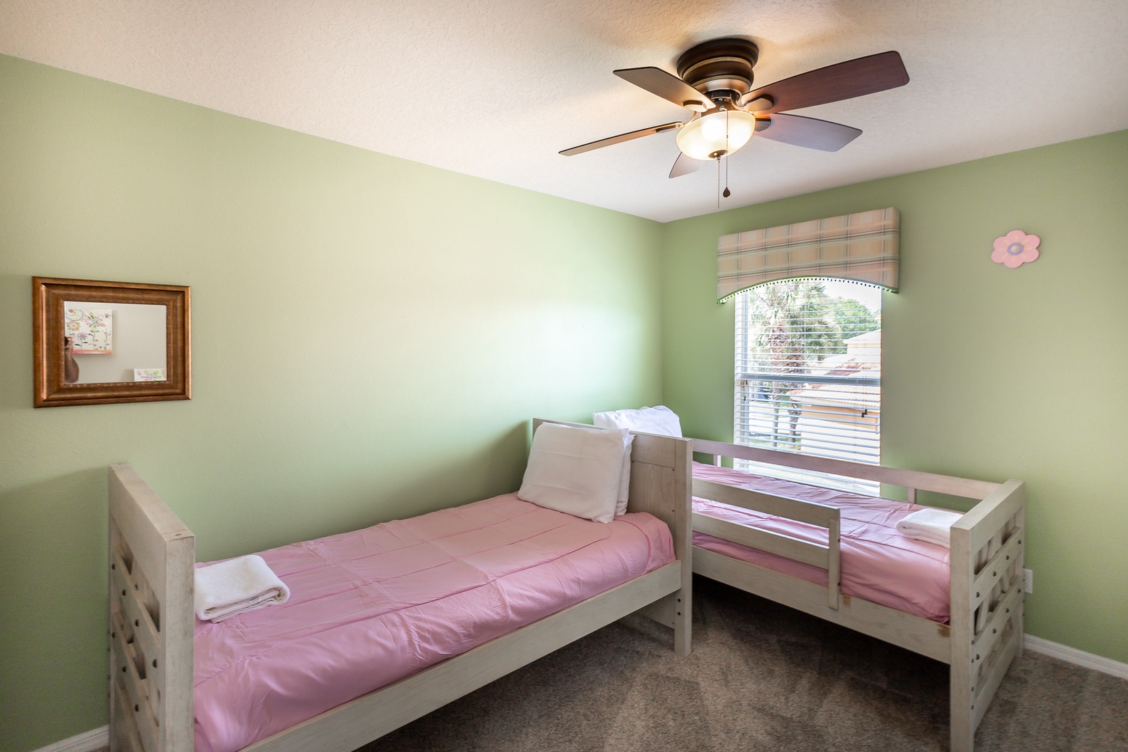 A 2nd twin bedroom offers a pair of twin beds, ceiling fan, & TV