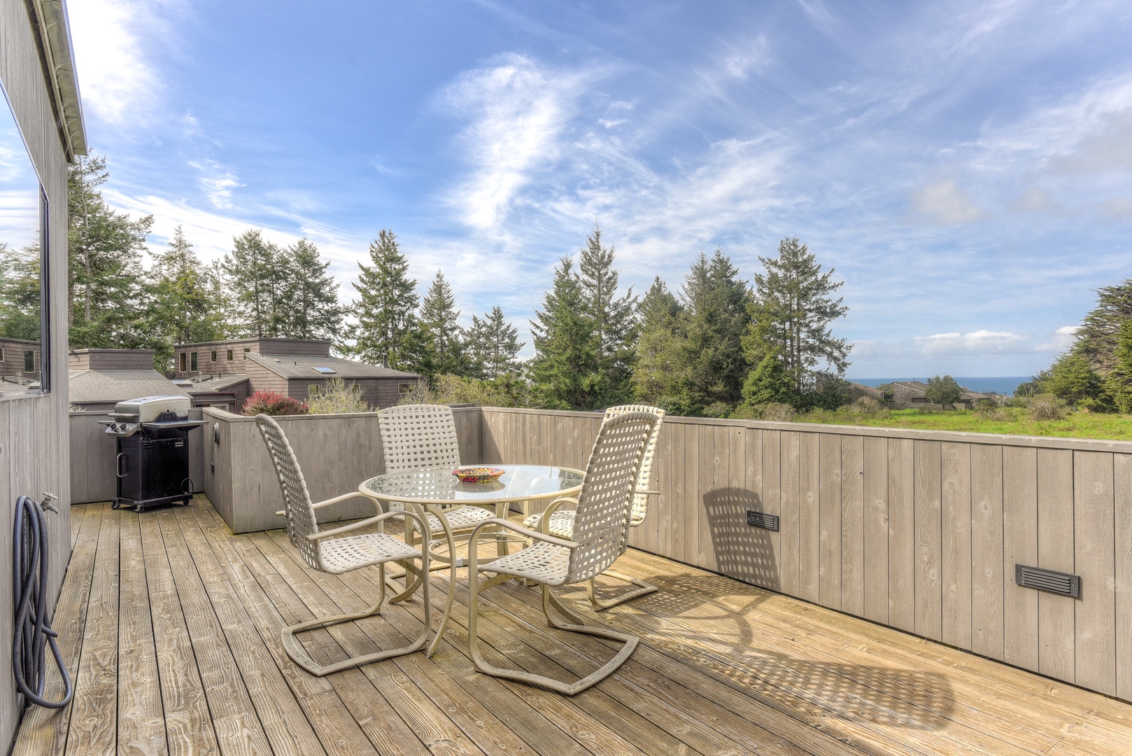 Spacious deck with outdoor seating, grill, and hot tub