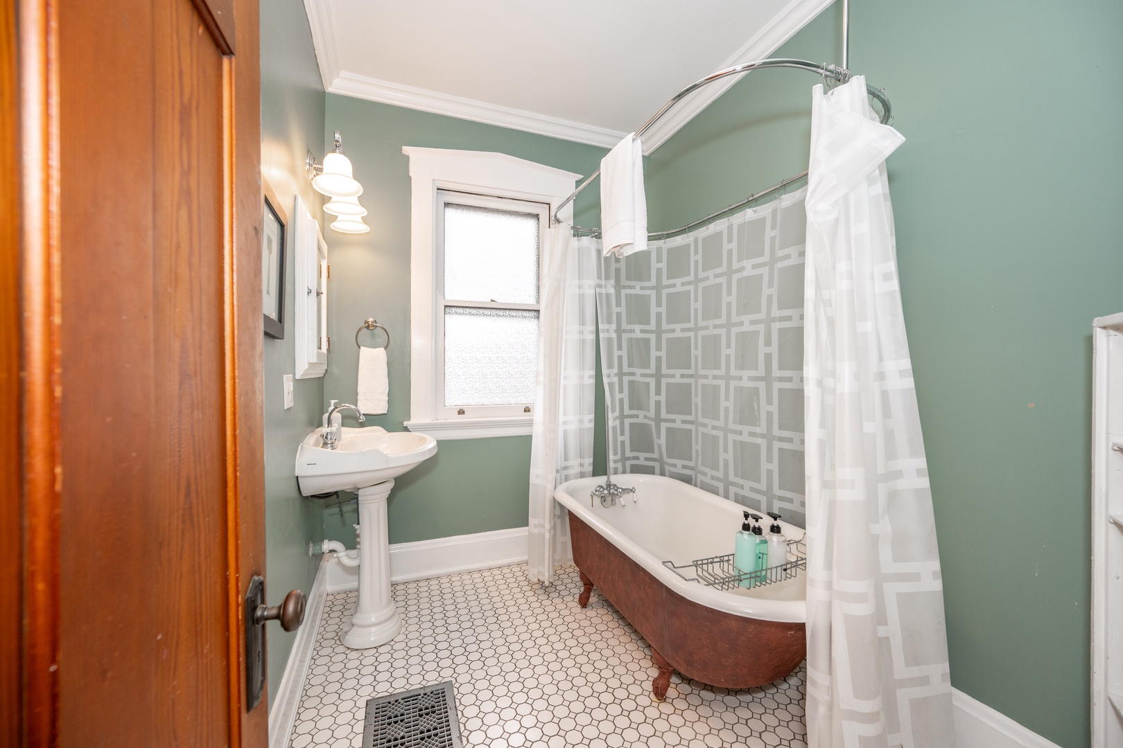 A pedestal sink & claw-foot tub with shower awaits in the 2nd floor full bath