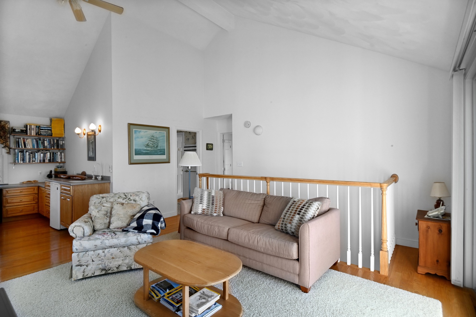 Upstairs living area with cozy seating, TV, work station, and balcony