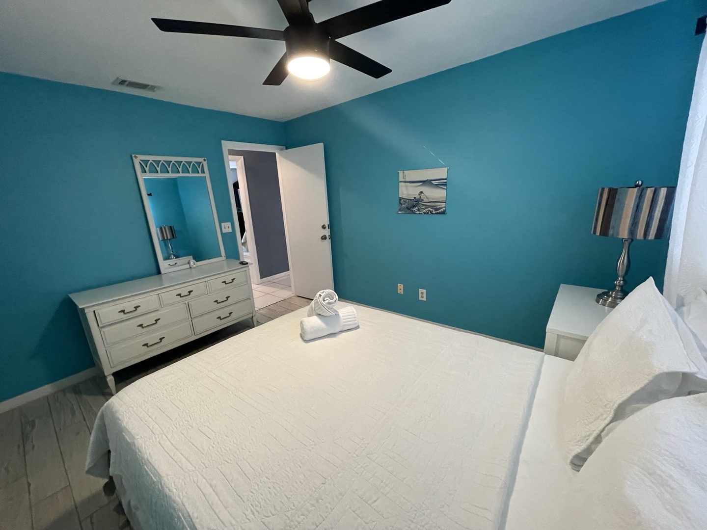 The final bedroom offers a plush queen bed & ceiling fan