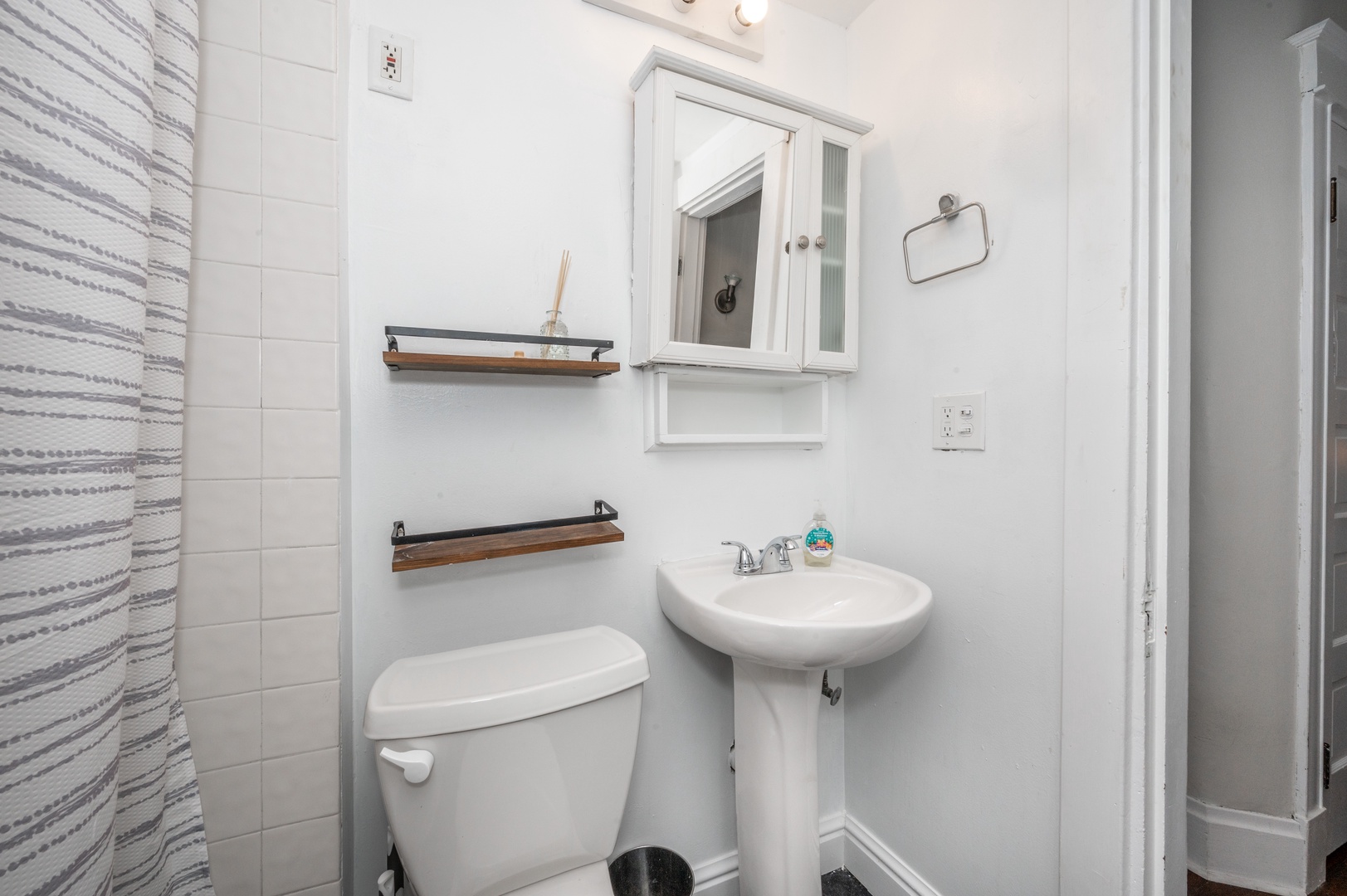 A pedestal sink & shower/tub combo await in the full bathroom