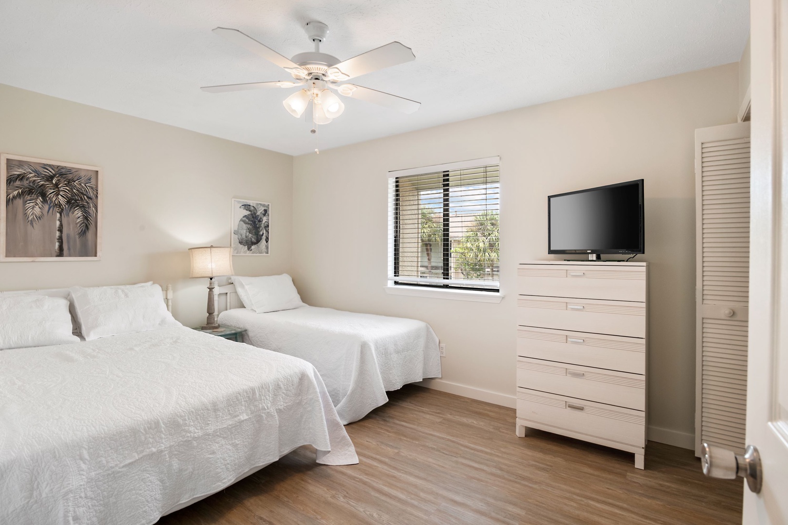 A queen bed, twin bed, & smart TV await in the second bedroom