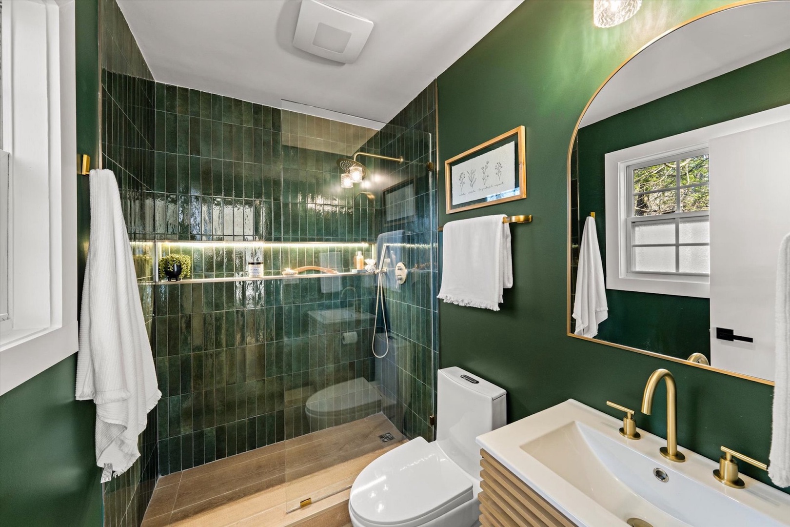 This luxurious ensuite offers a chic single vanity & spa-like glass shower