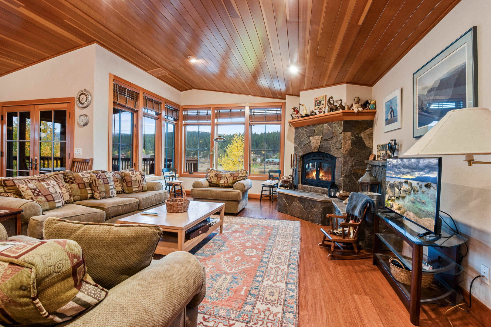 Living room with wood burning fireplace, flat screen TV and mountain views