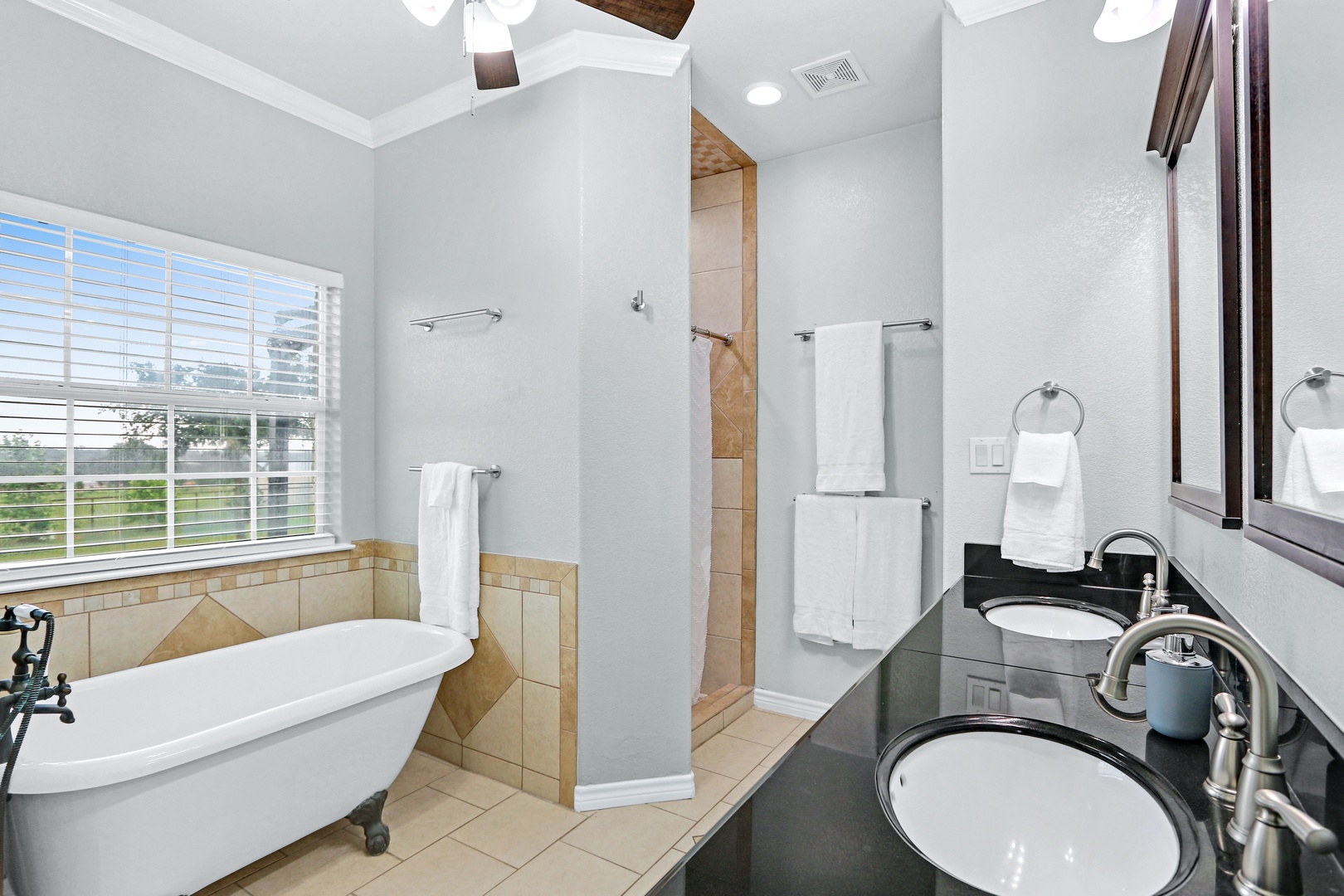 The king ensuite showcases a double vanity, walk-in shower, & soaking tub