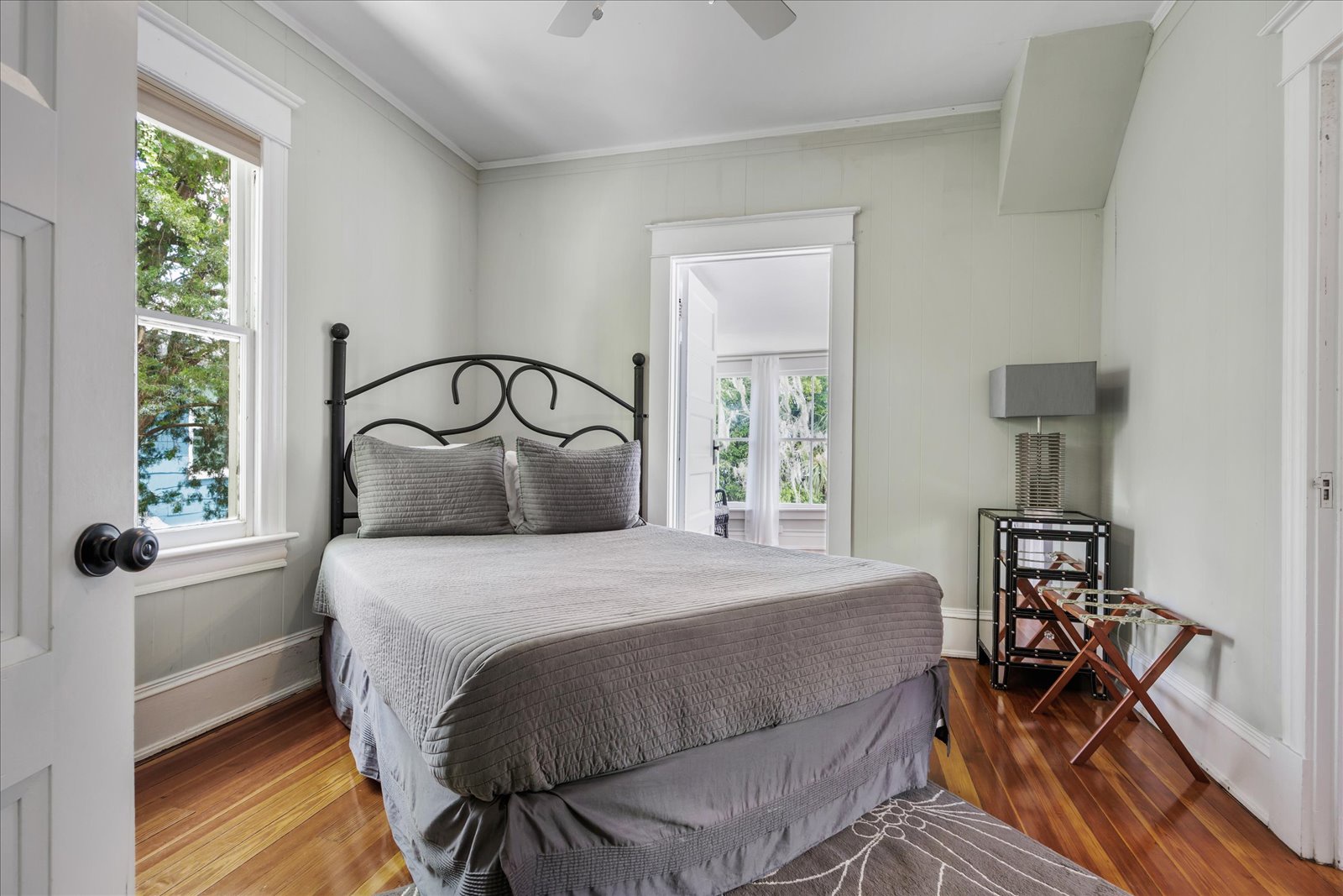The first of two bedrooms offers a queen bed & ceiling fan
