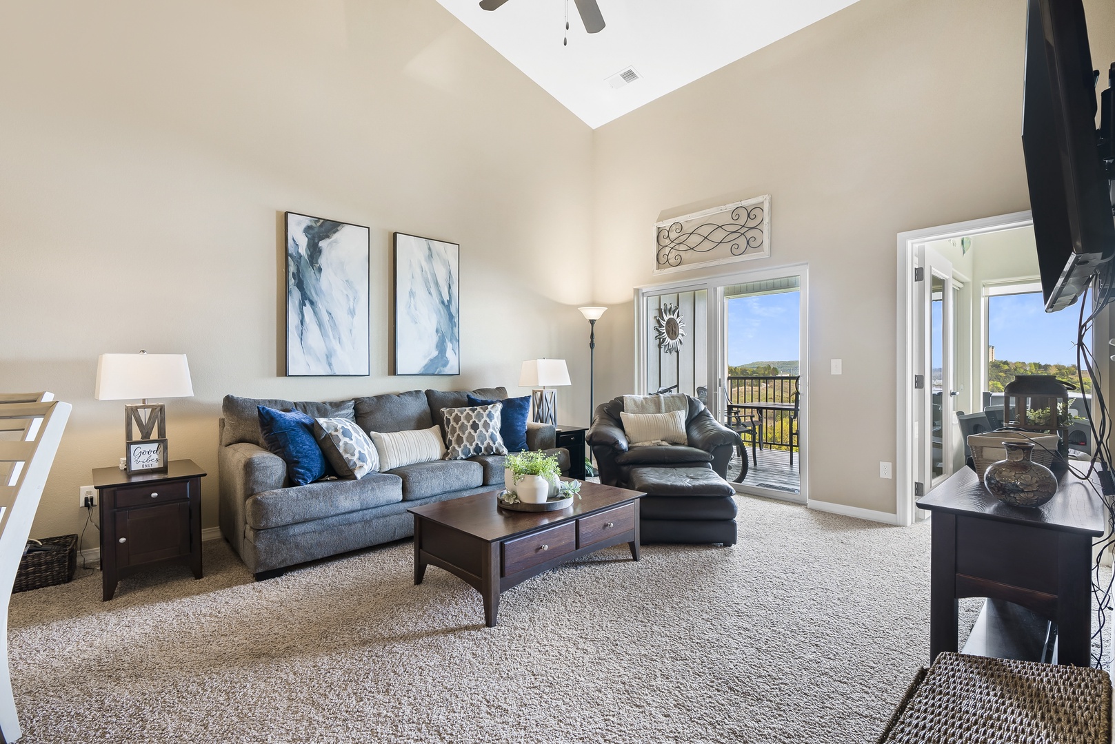 Living room with balcony access, sofa sleeper, and Smart TV