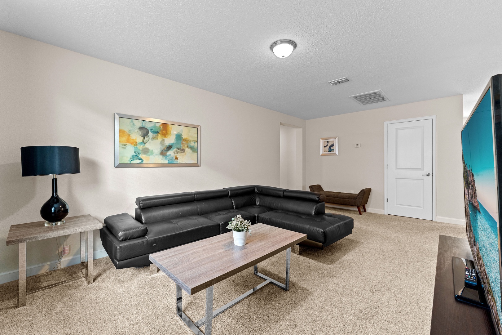 Second floor living area with leather seating and TV