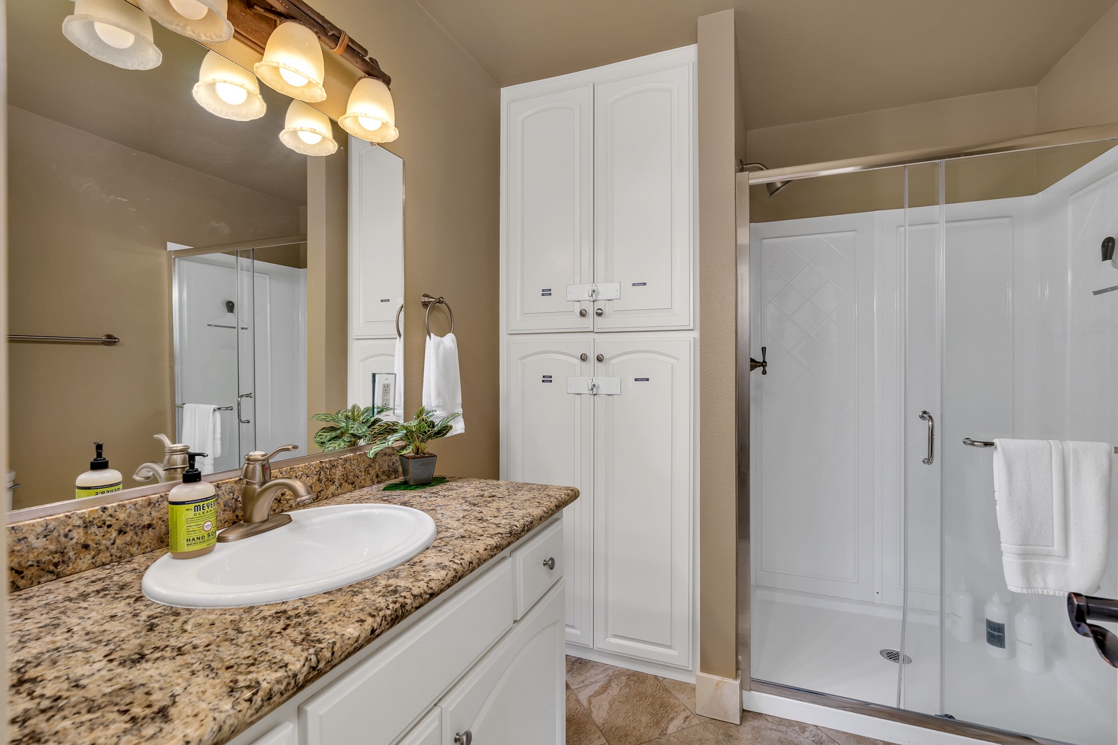 The lower-level full bathroom offers a large single vanity & glass shower
