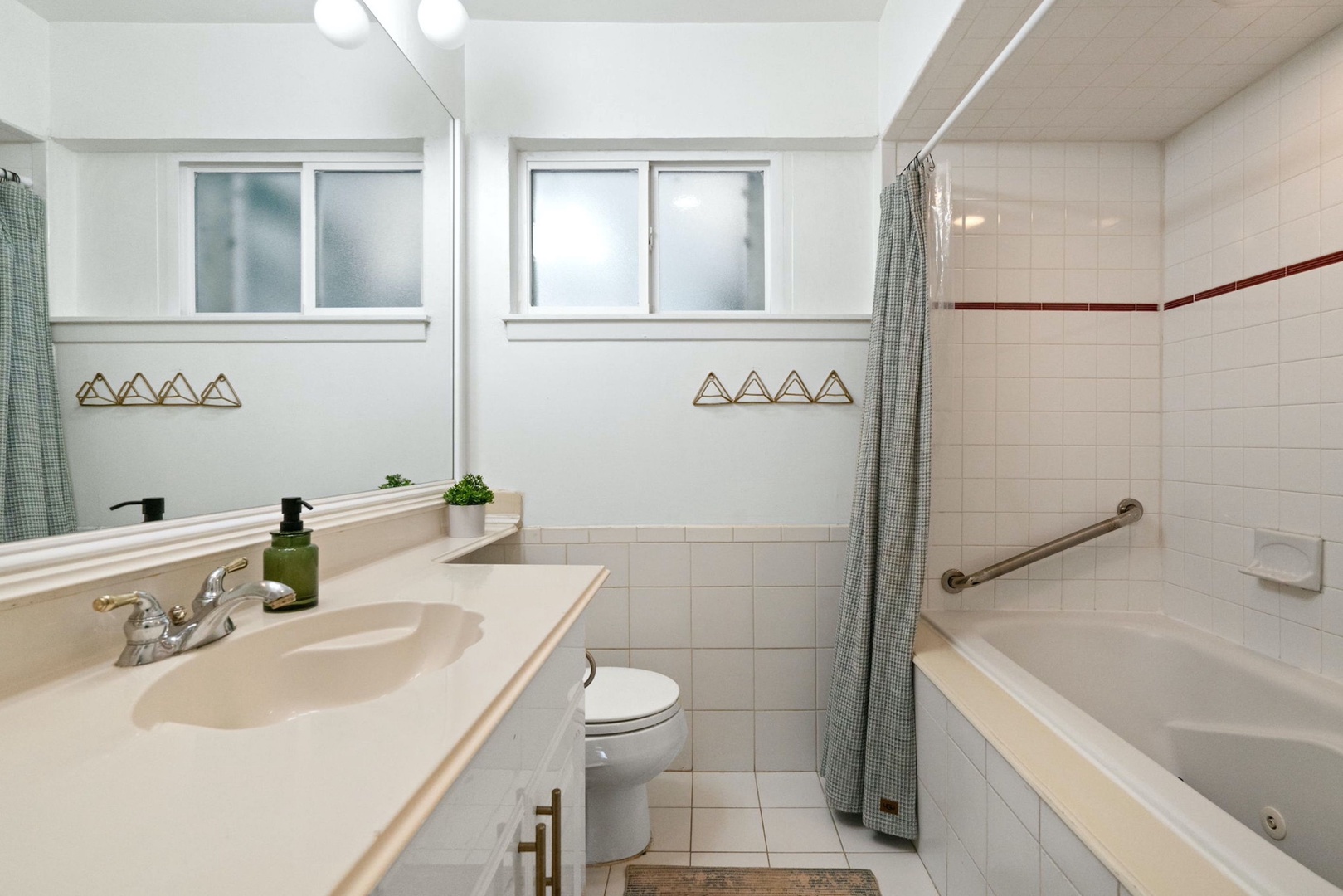 The main-floor full bath features a single vanity & shower/soaking tub combo
